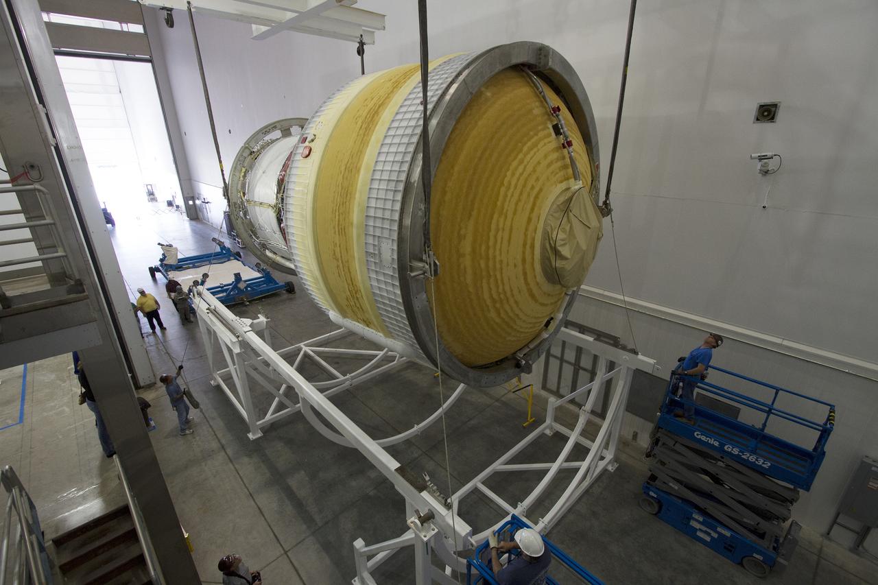 CAPE CANAVERAL, Fla. – Inside the Delta Operations Center near Space Launch Complex 37 on Cape Canaveral Air Force Station in Florida, the second stage for the United Launch Alliance Delta IV Heavy for Exploration Flight Test-1, or EFT-1, is lowered by crane into a cradle for the move to a test cell. At the Horizontal Integration Facility, all three booster stages will be processed and checked out before being moved to the nearby launch pad and hoisted into position. During the EFT-1 mission, Orion will travel farther into space than any human spacecraft has gone in more than 40 years. The data gathered during the flight will influence design decisions, validate existing computer models and innovative new approaches to space systems development, as well as reduce overall mission risks and costs for later Orion flights. Liftoff of Orion on EFT-1 is planned for fall 2014. Photo credit: NASA/Frankie Martin
