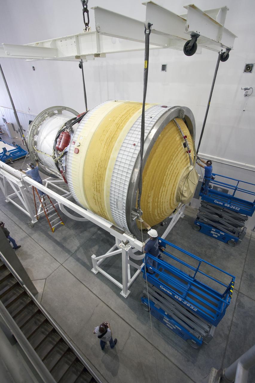 CAPE CANAVERAL, Fla. – Inside the Delta Operations Center near Space Launch Complex 37 on Cape Canaveral Air Force Station in Florida, the second stage for the United Launch Alliance Delta IV Heavy for Exploration Flight Test-1, or EFT-1, is lowered by crane into a cradle for the move to a test cell. At the Horizontal Integration Facility, all three booster stages will be processed and checked out before being moved to the nearby launch pad and hoisted into position. During the EFT-1 mission, Orion will travel farther into space than any human spacecraft has gone in more than 40 years. The data gathered during the flight will influence design decisions, validate existing computer models and innovative new approaches to space systems development, as well as reduce overall mission risks and costs for later Orion flights. Liftoff of Orion on EFT-1 is planned for fall 2014. Photo credit: NASA/Frankie Martin
