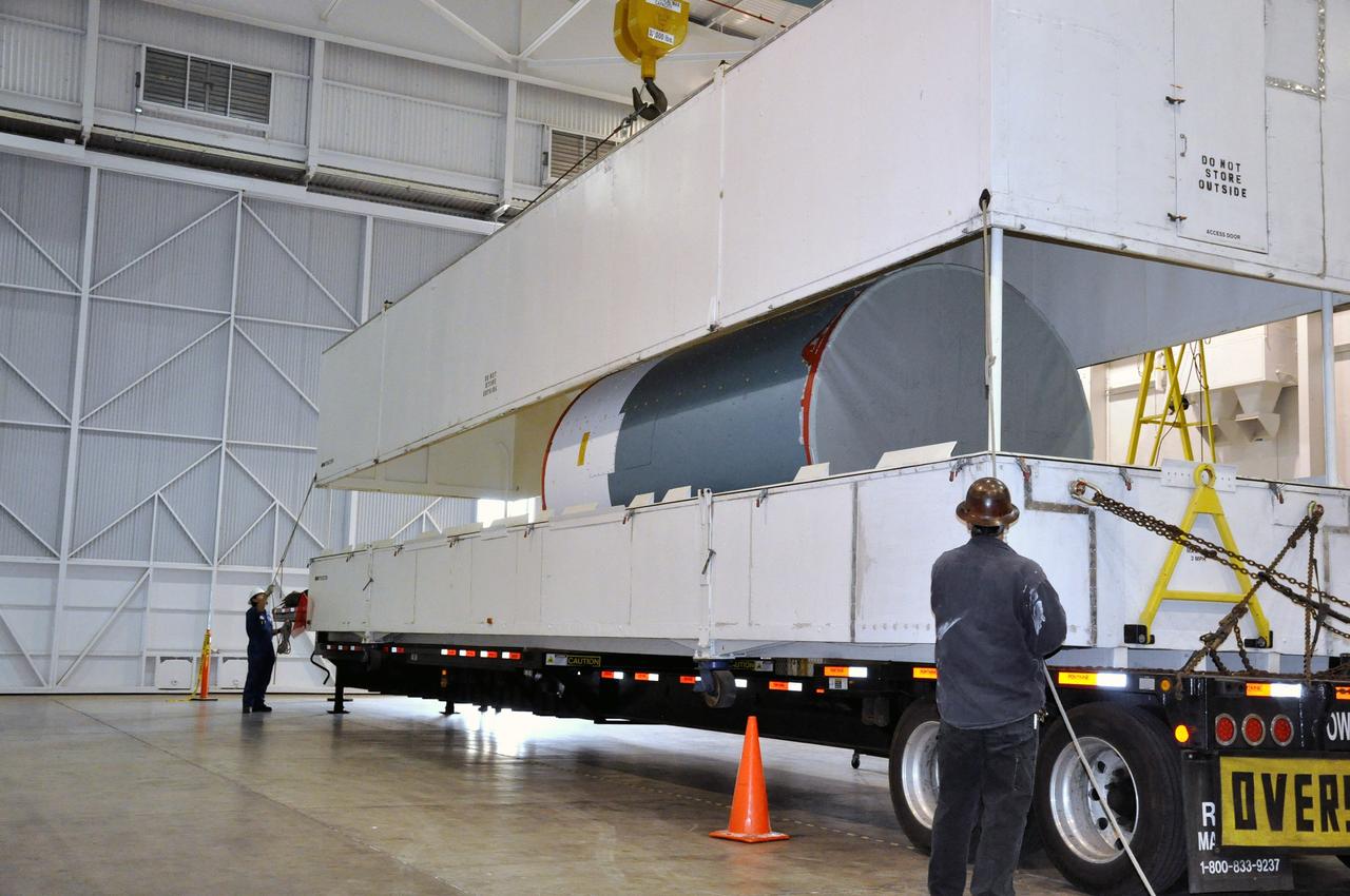 VANDENBERG AIR FORCE BASE, Calif. – As the cover of the transportation trailer is lifted in the high bay of the Building 836 hangar on south Vandenberg Air Force Base in California, the canister containing the interstage adapter, or ISA, for NASA's Soil Moisture Active Passive mission, or SMAP, comes into view.    A United Launch Alliance Delta II rocket will loft SMAP into orbit from Vandenberg's Space Launch Complex 2. The ISA connects the Delta II first and second stages and encloses the second stage engine and thrust section. The spacecraft will provide global measurements of soil moisture and its freeze/thaw state. These measurements will be used to enhance understanding of processes that link the water, energy and carbon cycles, and to extend the capabilities of weather and climate prediction models. The data returned also will be used to quantify net carbon flux in boreal landscapes and to develop improved flood prediction and drought monitoring capabilities. Launch is scheduled for November 2014. To learn more about SMAP, visit http://smap.jpl.nasa.gov.  Photo credit: NASA/Randy Beaudoin