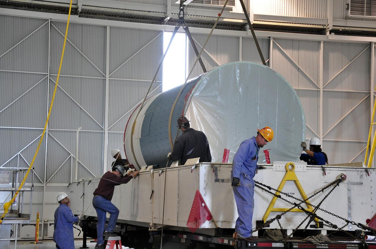 VANDENBERG AIR FORCE BASE, Calif. – Workers prepare to lift the canister containing the interstage adapter, or ISA, for NASA's Soil Moisture Active Passive mission, or SMAP, from its transportation trailer in the high bay of the Building 836 hangar on south Vandenberg Air Force Base in California.    A United Launch Alliance Delta II rocket will loft SMAP into orbit from Vandenberg's Space Launch Complex 2. The ISA connects the Delta II first and second stages and encloses the second stage engine and thrust section. The spacecraft will provide global measurements of soil moisture and its freeze/thaw state. These measurements will be used to enhance understanding of processes that link the water, energy and carbon cycles, and to extend the capabilities of weather and climate prediction models. The data returned also will be used to quantify net carbon flux in boreal landscapes and to develop improved flood prediction and drought monitoring capabilities. Launch is scheduled for November 2014. To learn more about SMAP, visit http://smap.jpl.nasa.gov.  Photo credit: NASA/Randy Beaudoin