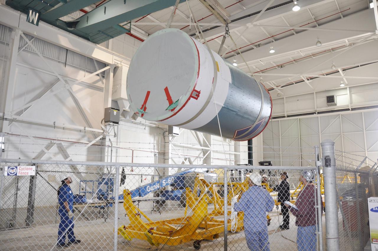 VANDENBERG AIR FORCE BASE, Calif. – Workers lower the interstage adapter, or ISA, for NASA's Soil Moisture Active Passive mission, or SMAP, toward a flight hardware cradle in the high bay of the Building 836 hangar on south Vandenberg Air Force Base in California.    A United Launch Alliance Delta II rocket will loft SMAP into orbit from Vandenberg's Space Launch Complex 2. The ISA connects the Delta II first and second stages and encloses the second stage engine and thrust section. The spacecraft will provide global measurements of soil moisture and its freeze/thaw state. These measurements will be used to enhance understanding of processes that link the water, energy and carbon cycles, and to extend the capabilities of weather and climate prediction models. The data returned also will be used to quantify net carbon flux in boreal landscapes and to develop improved flood prediction and drought monitoring capabilities. Launch is scheduled for November 2014. To learn more about SMAP, visit http://smap.jpl.nasa.gov.  Photo credit: NASA/Randy Beaudoin