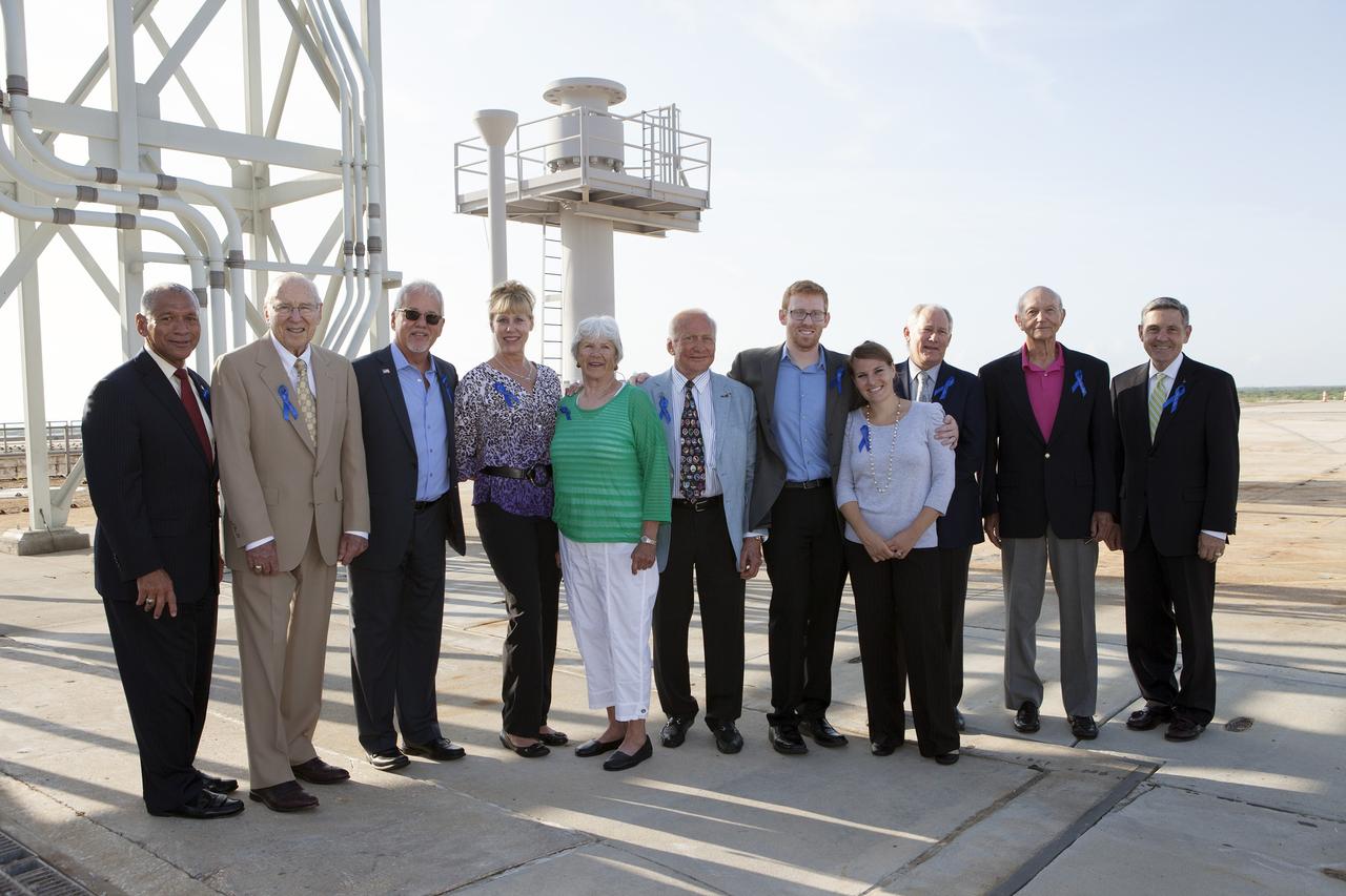 CAPE CANAVERAL, Fla. -- At NASA's Kennedy Space Center in Florida, NASA officials and Apollo astronauts visiting Launch Pad 39B with their families and friends preserve the moment with a group portrait. The group was at Kennedy for a ceremony renaming the Operations and Checkout Building for Apollo 11 astronaut Neil Armstrong, the first person to set foot on the moon. From left are NASA Administrator Charles Bolden, Apollo astronaut Jim Lovell, Buzz Aldrin's grandson Jeffrey Schuss, Jeffrey's wife April Schuss, Neil's former wife Janet Armstrong, Apollo 11 moonwalker Buzz Aldrin, Buzz's son-in-law Bruce Hanifan, Buzz's daughter Jan Aldrin, Buzz's son Andy Aldrin, Apollo 11 command module pilot Mike Collins, and Center Director Bob Cabana. The pad is being modified to support the agency's new Orion spacecraft which will lift off atop the Space Launch System rocket. Orion is designed to take humans farther than they’ve ever gone before, serving as the exploration vehicle that will carry astronauts to deep space and sustain the crew during travel to destinations such as an asteroid or Mars.      The visit of the former astronauts was part of NASA's 45th anniversary celebration of the Apollo 11 moon landing. As the world watched, Neil Armstrong and Neil Aldrin landed in the moon's Sea of Tranquility aboard the lunar module Eagle on July 20, 1969. Meanwhile, crewmate Michael Collins orbited above in the command module Columbia. For more, visit http://www.nasa.gov/press/2014/july/nasa-honors-historic-first-moon-landing-eyes-first-mars-mission. Photo credit: NASA/Kim Shiflett