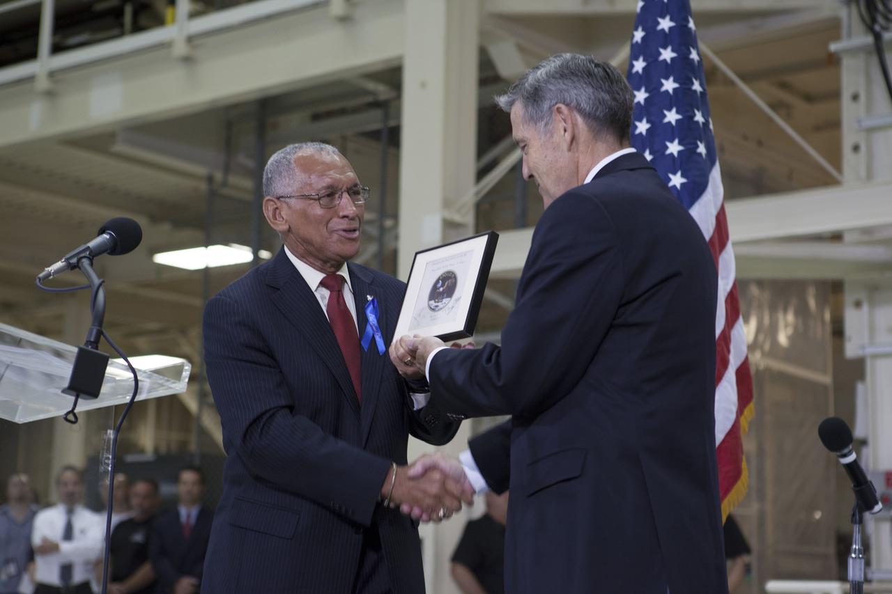 CAPE CANAVERAL, Fla. -- At the Kennedy Space Center in Florida, NASA Administrator Charles Bolden, left, presents Center Director Robert Cabana with an Apollo 11 patch that flew to the moon on the Apollo 11 mission and is signed by all three Apollo 11 astronauts. The patch will remain at Kennedy until the first human spaceflight to Mars, when it will fly once again. The presentation was made during a ceremony renaming the refurbished Operations and Checkout Building for Apollo 11 astronaut Neil Armstrong, the first person to set foot on the moon. The building's high bay, in which the ceremony was held, is being used to support the agency's new Orion spacecraft and is the same spaceport facility where the Apollo 11 command/service module and lunar module were prepped for the first lunar landing mission in 1969. Orion is designed to take humans farther than they’ve ever gone before, serving as the exploration vehicle that will carry astronauts to deep space and sustain the crew during travel to destinations such as an asteroid or Mars. The ceremony was part of NASA's 45th anniversary celebration of the Apollo 11 moon landing. As the world watched, Neil Armstrong and Buzz Aldrin landed in the moon's Sea of Tranquility on July 20, 1969, aboard the lunar module Eagle. Meanwhile, crewmate Michael Collins orbited above in the command module Columbia. For more, visit http://www.nasa.gov/press/2014/july/nasa-honors-historic-first-moon-landing-eyes-first-mars-mission. Photo credit: NASA/Kim Shiflett