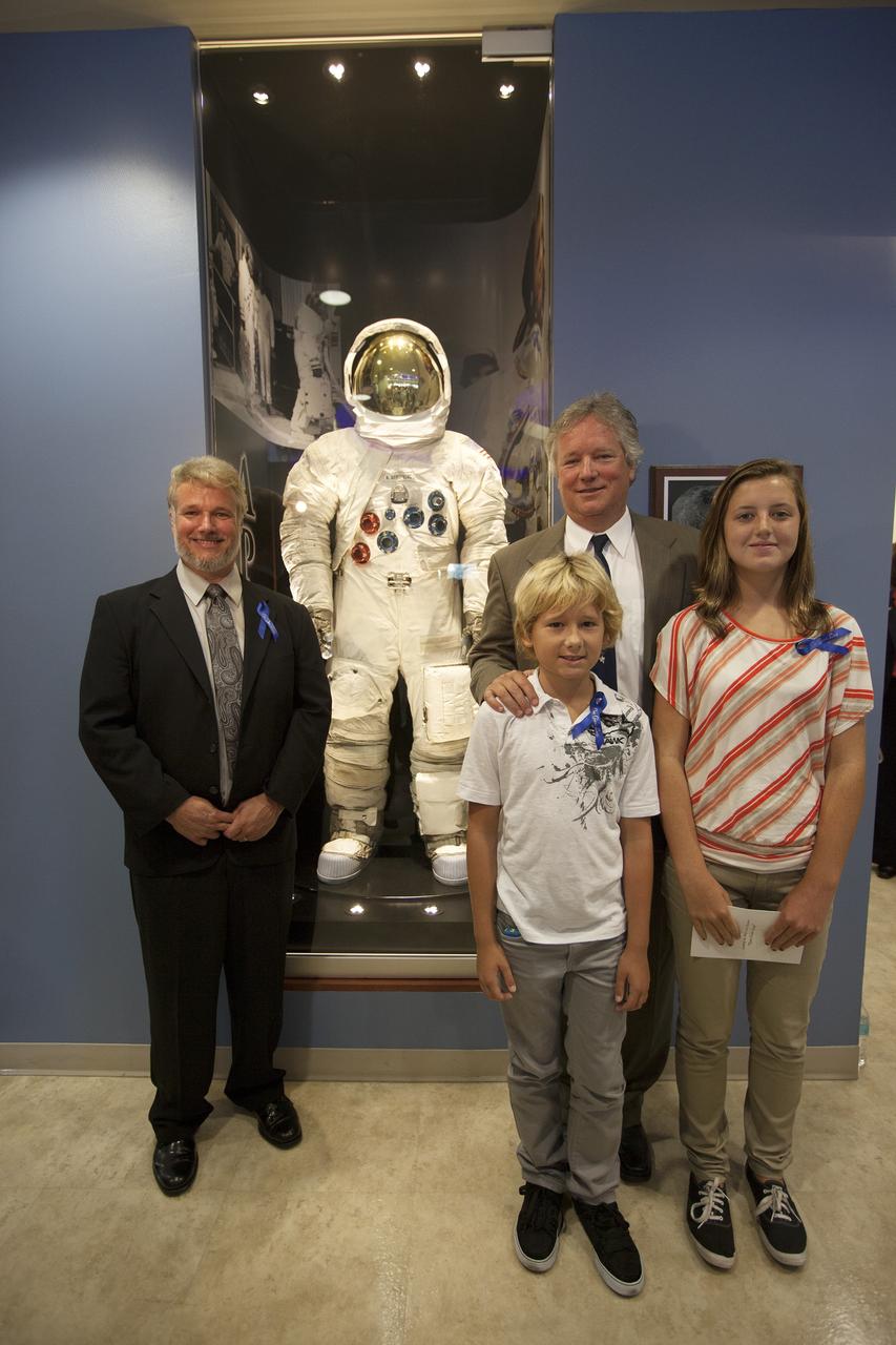 CAPE CANAVERAL, Fla. -- At the Kennedy Space Center in Florida, members of the Armstrong family pose for a portrait with an Apollo-era spacesuit following its unveiling in the lobby of the newly named Neil Armstrong Operations and Checkout Building. The facility has been renamed for Apollo 11 astronaut Neil Armstrong, the first person to set foot on the moon. From left are Armstrong's son Mark, his grandson Bryce, his son Rick and his granddaughter Lily. The building's high bay is being used to support the agency's new Orion spacecraft and is the same spaceport facility where the Apollo 11 command/service module and lunar module were prepped for the first lunar landing mission in 1969. Orion is designed to take humans farther than they’ve ever gone before, serving as the exploration vehicle that will carry astronauts to deep space and sustain the crew during travel to destinations such as an asteroid or Mars.    The unveiling was part of NASA's 45th anniversary celebration of the Apollo 11 moon landing. As the world watched, Apollo 11 astronauts landed in the moon's Sea of Tranquility aboard the lunar module, Eagle, on July 20, 1969, as the command module, Columbia, orbited overhead. For more: http://www.nasa.gov/press/2014/july/nasa-honors-historic-first-moon-landing-eyes-first-mars-mission/ Photo credit: NASA/Kim Shiflett