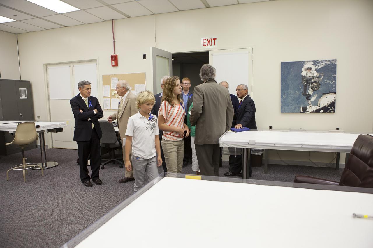 CAPE CANAVERAL, Fla. -- Apollo astronauts and their families tour the astronaut crew quarters in the Operations and Checkout Building at NASA's Kennedy Space Center in Florida. The tour followed a ceremony renaming the refurbished Operations and Checkout Building for Apollo 11 astronaut Neil Armstrong, the first person to set foot on the moon. Here, Armstrong's grandchildren, Bryce and Lily, in front, make their way into the room. Center Director Robert Cabana talks with Apollo 8 and Apollo 13 crew member Jim Lovell, at left, as NASA Administrator Charles Bolden talks with other Armstrong family members, at right. Besides housing the crew quarters, the building's high bay is being used to support the agency's new Orion spacecraft and is the same spaceport facility where the Apollo 11 command/service module and lunar module were prepped for the first lunar landing mission in 1969. Orion is designed to take humans farther than they’ve ever gone before, serving as the exploration vehicle that will carry astronauts to deep space and sustain the crew during travel to destinations such as an asteroid or Mars. The ceremony was part of NASA's 45th anniversary celebration of the Apollo 11 moon landing. As the world watched, Neil Armstrong and Buzz Aldrin landed in the moon's Sea of Tranquility on July 20, 1969, aboard the lunar module Eagle. Meanwhile, crewmate Michael Collins orbited above in the command module Columbia. For more, visit http://www.nasa.gov/press/2014/july/nasa-honors-historic-first-moon-landing-eyes-first-mars-mission. Photo credit: NASA/Kim Shiflett