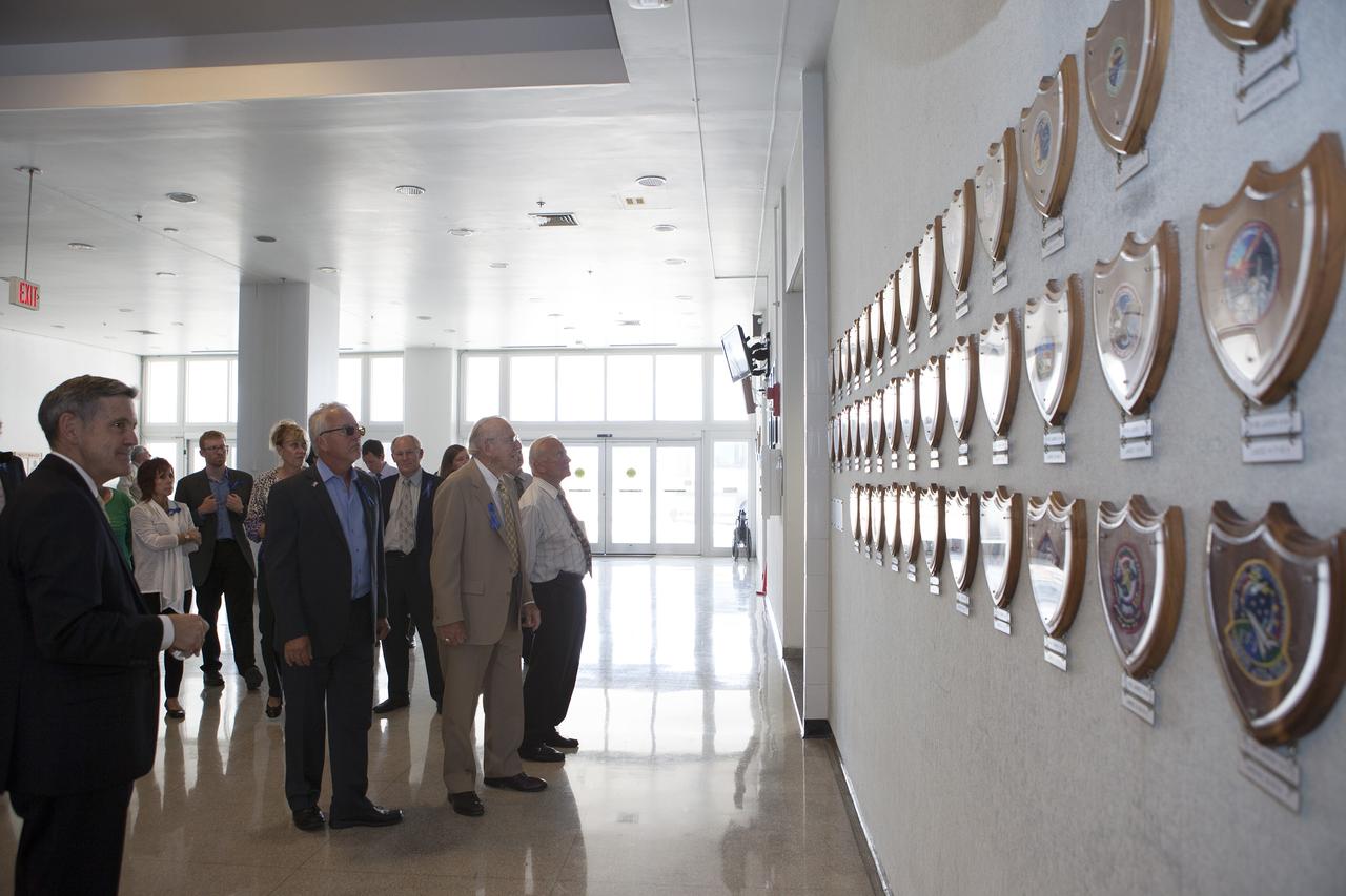 CAPE CANAVERAL, Fla. -- Apollo astronauts and their families examine the mission plaques mounted on the wall in the lobby of the Launch Control Center at NASA's Kennedy Space Center in Florida. The facility houses the firing rooms from which the Apollo countdowns were conducted. Kennedy Director Robert Cabana, at left, led the tour which followed a ceremony renaming the refurbished Operations and Checkout Building for Apollo 11 astronaut Neil Armstrong, the first person to set foot on the moon.    The ceremony was part of NASA's 45th anniversary celebration of the Apollo 11 moon landing. As the world watched, Neil Armstrong and Buzz Aldrin landed in the moon's Sea of Tranquility on July 20, 1969, aboard the lunar module Eagle. Meanwhile, crewmate Michael Collins orbited above in the command module Columbia. For more, visit http://www.nasa.gov/press/2014/july/nasa-honors-historic-first-moon-landing-eyes-first-mars-mission.  Photo credit: NASA/Kim Shiflett