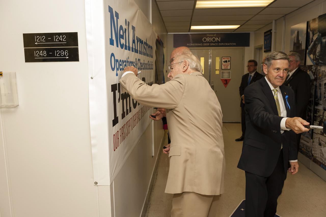 CAPE CANAVERAL, Fla. -- Apollo astronauts and their families receive a briefing in one of the remodeled firing rooms in the Launch Control Center at NASA's Kennedy Space Center in Florida. The facility's firing rooms were used to conduct the Saturn V countdowns during the Apollo Program. The tour followed a ceremony renaming the refurbished Operations and Checkout Building for Apollo 11 astronaut Neil Armstrong, the first person to set foot on the moon. Second from left is Apollo 11 moonwalker Buzz Aldrin and former astronaut Jim Lovell, a member of the Apollo 8 and Apollo 13 crews, standing next to him, at center.    The ceremony was part of NASA's 45th anniversary celebration of the Apollo 11 moon landing. As the world watched, Neil Armstrong and Buzz Aldrin landed in the moon's Sea of Tranquility on July 20, 1969, aboard the lunar module Eagle. Meanwhile, crewmate Michael Collins orbited above in the command module Columbia. For more, visit http://www.nasa.gov/press/2014/july/nasa-honors-historic-first-moon-landing-eyes-first-mars-mission. Photo credit: NASA/Kevin O'Connell