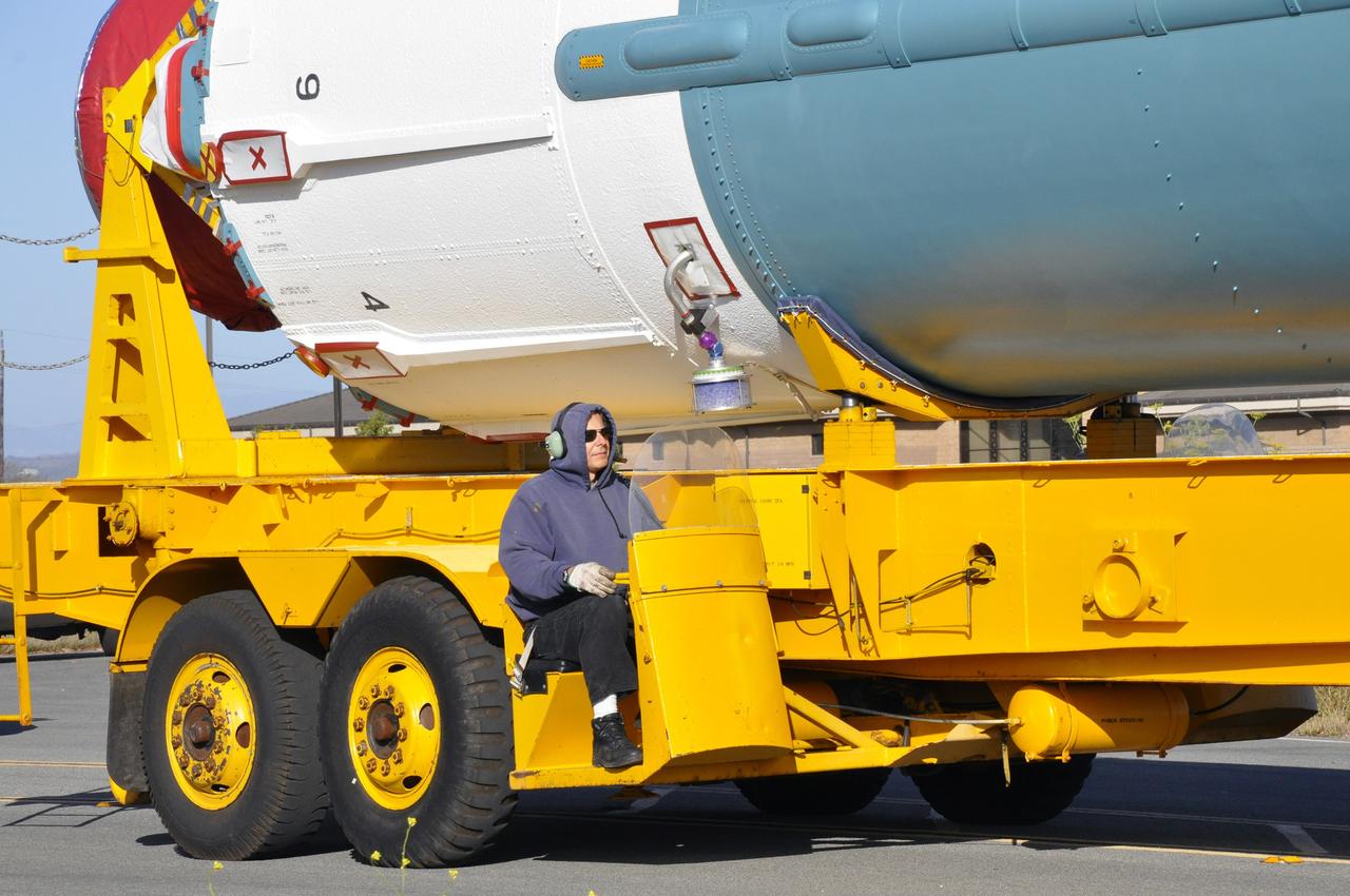 VANDENBERG AIR FORCE BASE, Calif. – A worker is stationed on the transporter carrying the first stage of the United Launch Alliance Delta II rocket for NASA's Soil Moisture Active Passive mission, or SMAP, from the Building 836 hangar to the Horizontal Processing Facility at Space Launch Complex 2 on Vandenberg Air Force Base in California.    SMAP will provide global measurements of soil moisture and its freeze/thaw state. These measurements will be used to enhance understanding of processes that link the water, energy and carbon cycles, and to extend the capabilities of weather and climate prediction models. SMAP data also will be used to quantify net carbon flux in boreal landscapes and to develop improved flood prediction and drought monitoring capabilities. Launch is scheduled for November 2014. To learn more about SMAP, visit http://smap.jpl.nasa.gov.  Photo credit: NASA/Randy Beaudoin