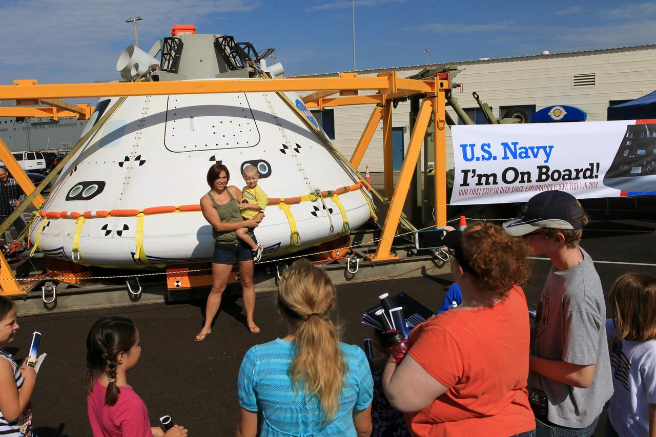 SAN DIEGO, Calif. – At the U.S. Naval Base San Diego in California, visitors take photographs in front of the Orion boilerplate test vehicle during an outreach event at the naval base. The USS Anchorage is being prepared for the Orion Underway Recovery Test 2. The test vehicle and other hardware will be loaded into the well deck of the ship and head out to sea in the Pacific Ocean off the coast of San Diego. NASA, Lockheed Martin and the U.S. Navy will conduct the test to prepare for recovery of the Orion crew module, forward bay cover and parachutes on its return from a deep space mission. The underway recovery test will allow the teams to demonstrate and evaluate the recovery processes, procedures, new support hardware and personnel in open waters. The Ground Systems Development and Operations Program will conduct the underway recovery tests. Orion is the exploration spacecraft designed to carry astronauts to destinations not yet explored by humans, including an asteroid and Mars. It will have emergency abort capability, sustain the crew during space travel and provide safe re-entry from deep space return velocities. The first unpiloted test flight of the Orion is scheduled to launch in 2014 atop a Delta IV rocket and in 2017 on NASA’s Space Launch System rocket. For more information, visit http://www.nasa.gov/orion. Photo credit: NASA/Kim Shiflett
