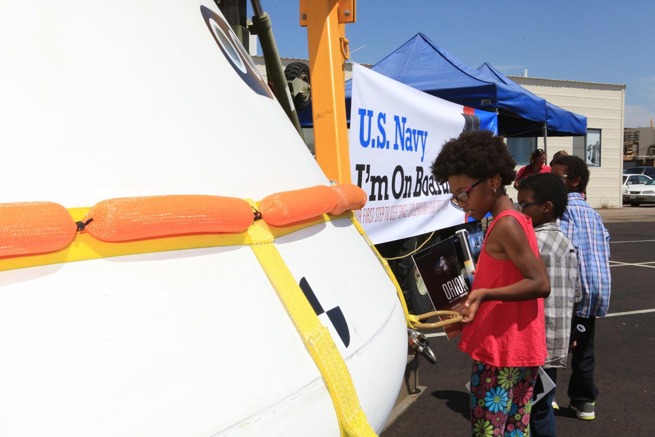 SAN DIEGO, Calif. – At the U.S. Naval Base San Diego in California, children sign a banner and view the Orion boilerplate test vehicle during an outreach event at the naval base. The USS Anchorage is being prepared for the Orion Underway Recovery Test 2. The test vehicle and other hardware will be loaded into the well deck of the ship and head out to sea in the Pacific Ocean off the coast of San Diego. NASA, Lockheed Martin and the U.S. Navy will conduct the test to prepare for recovery of the Orion crew module, forward bay cover and parachutes on its return from a deep space mission. The underway recovery test will allow the teams to demonstrate and evaluate the recovery processes, procedures, new support hardware and personnel in open waters. The Ground Systems Development and Operations Program will conduct the underway recovery tests. Orion is the exploration spacecraft designed to carry astronauts to destinations not yet explored by humans, including an asteroid and Mars. It will have emergency abort capability, sustain the crew during space travel and provide safe re-entry from deep space return velocities. The first unpiloted test flight of the Orion is scheduled to launch in 2014 atop a Delta IV rocket and in 2017 on NASA’s Space Launch System rocket. For more information, visit http://www.nasa.gov/orion. Photo credit: NASA/Kim Shiflett