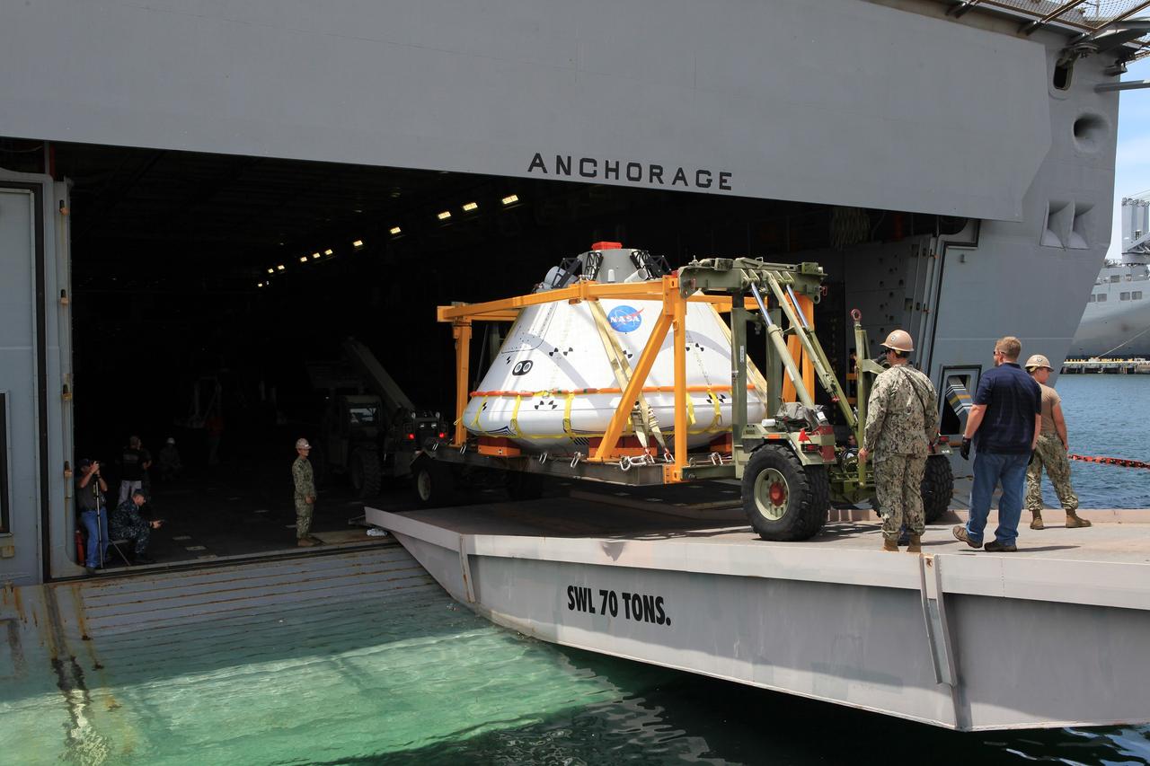 SAN DIEGO, Calif. – At the U.S. Naval Base San Diego in California, the Orion boilerplate test vehicle and support hardware are loaded in the well deck of the USS Anchorage for Underway Recovery Test 2. NASA, Lockheed Martin and the U.S. Navy will conduct tests in the Pacific Ocean to prepare for recovery of the Orion crew module, forward bay cover and parachutes on its return from a deep space mission. The second underway recovery test will allow the teams to demonstrate and evaluate the recovery processes, procedures, new hardware and personnel in open waters.    The Ground Systems Development and Operations Program is conducting the underway recovery tests. Orion is the exploration spacecraft designed to carry astronauts to destinations not yet explored by humans, including an asteroid and Mars. It will have emergency abort capability, sustain the crew during space travel and provide safe re-entry from deep space return velocities. The first unpiloted test flight of the Orion is scheduled to launch in 2014 atop a Delta IV rocket and in 2017 on NASA’s Space Launch System rocket. For more information, visit http://www.nasa.gov/orion. Photo credit: NASA/Kim Shiflett