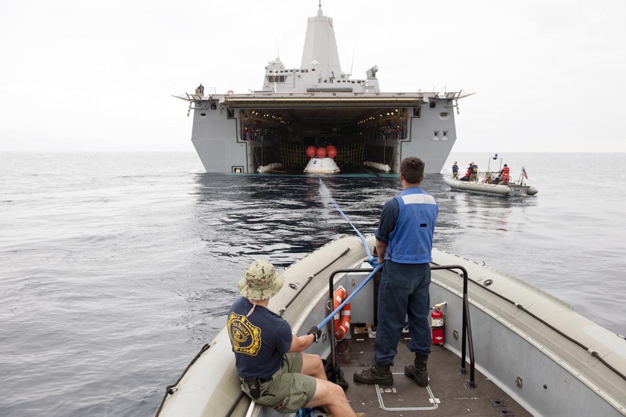 SAN DIEGO, Calif. – U.S. Navy personnel in a rigid hull inflatable boat practice with tether lines attached to the Orion boilerplate test vehicle during an evolution of the Underway Recovery Test 2 near the USS Anchorage in the Pacific Ocean off the coast of San Diego. The vehicle is outside of the ship. NASA, Lockheed Martin and the U.S. Navy are conducting the test to prepare for recovery of the Orion crew module on its return from a deep space mission. The underway recovery test will allow the teams to demonstrate and evaluate the recovery processes, procedures, new hardware and personnel in open waters. The Ground Systems Development and Operations Program is conducting the underway recovery test. Orion is the exploration spacecraft designed to carry astronauts to destinations not yet explored by humans, including an asteroid and Mars. It will have emergency abort capability, sustain the crew during space travel and provide safe re-entry from deep space return velocities. The first unpiloted test flight of the Orion is scheduled to launch in 2014 atop a Delta IV rocket and in 2017 on NASA’s Space Launch System rocket. For more information, visit http://www.nasa.gov/orion. Photo credit: NASA/Tony Gray