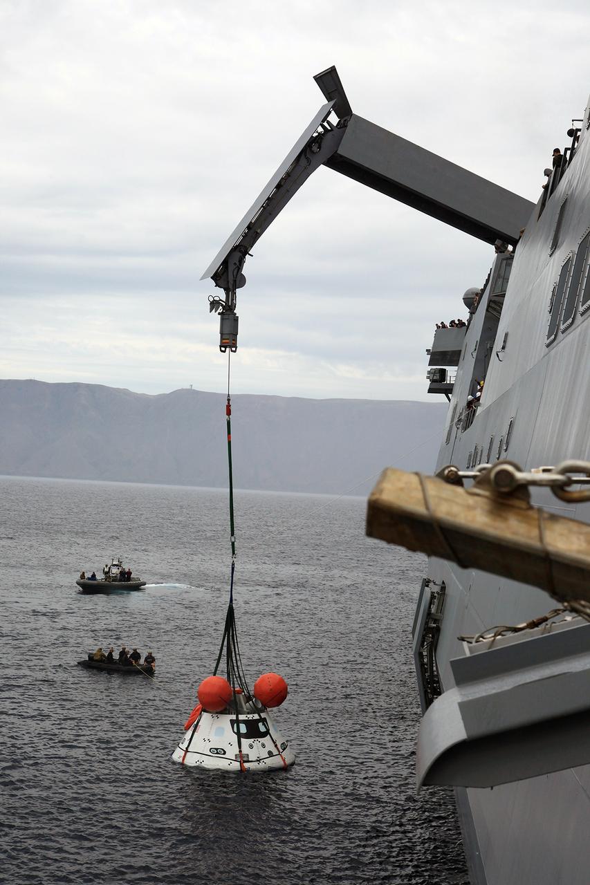 SAN DIEGO, Calif. – The Orion boilerplate test vehicle is slightly lifted by crane from the water to test the proof of concept basket lift method during an evolution of the Underway Recovery Test 2 near the USS Anchorage in the Pacific Ocean off the coast of San Diego. U.S. Navy personnel are nearby in two rigid hull inflatable boats. NASA, Lockheed Martin and the U.S. Navy are conducting the test to prepare for recovery of the Orion crew module on its return from a deep space mission. The underway recovery test will allow the teams to demonstrate and evaluate the recovery processes, procedures, new hardware and personnel in open waters. The Ground Systems Development and Operations Program is conducting the underway recovery test. Orion is the exploration spacecraft designed to carry astronauts to destinations not yet explored by humans, including an asteroid and Mars. It will have emergency abort capability, sustain the crew during space travel and provide safe re-entry from deep space return velocities. The first unpiloted test flight of the Orion is scheduled to launch in 2014 atop a Delta IV rocket and in 2017 on NASA’s Space Launch System rocket. For more information, visit http://www.nasa.gov/orion. Photo credit: NASA/Kim Shiflett