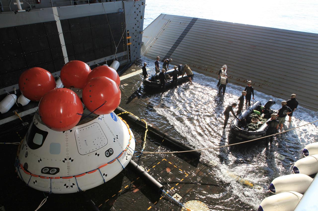 SAN DIEGO, Calif. – U.S. Navy personnel get ready to board two rigid hull inflatable boats in the well deck of the USS Anchorage to prepare for an evolution of the Orion Underway Recovery Test 2 in the Pacific Ocean off the coast of San Diego. Nearby, tending lines have been attached to the Orion boilerplate test vehicle as the well deck fills with water. NASA, Lockheed Martin and the U.S. Navy are conducting the test to prepare for recovery of the Orion crew module on its return from a deep space mission. The underway recovery test will allow the teams to demonstrate and evaluate the recovery processes, procedures, new hardware and personnel in open waters. The Ground Systems Development and Operations Program is conducting the underway recovery test. Orion is the exploration spacecraft designed to carry astronauts to destinations not yet explored by humans, including an asteroid and Mars. It will have emergency abort capability, sustain the crew during space travel and provide safe re-entry from deep space return velocities. The first unpiloted test flight of the Orion is scheduled to launch in 2014 atop a Delta IV rocket and in 2017 on NASA’s Space Launch System rocket. For more information, visit http://www.nasa.gov/orion. Photo credit: NASA/Kim Shiflett