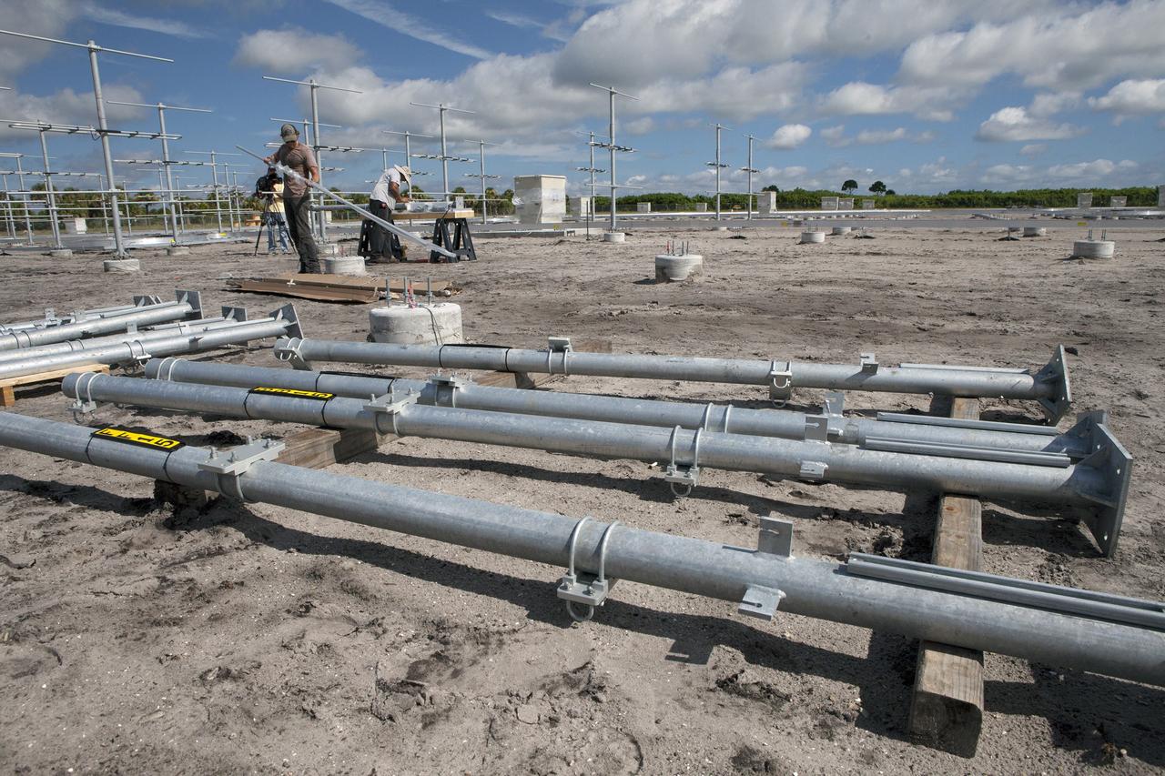 CAPE CANAVERAL, Fla. – From left, Jacob Walls and Felix Gamez of Qinetiq North America work on the installation of new antennas in the antenna field for NASA Kennedy Space Center’s Doppler radar wind profiler.     Located near the spaceport’s Shuttle Landing Facility runway, the profiler is being upgraded to a new, state-of-the-art version that will help forecasters and launch teams characterize upper-level winds in the area. This profiler will help in the detection of wind-shear conditions during launch. Photo credit: NASA/Ben Smegelsky