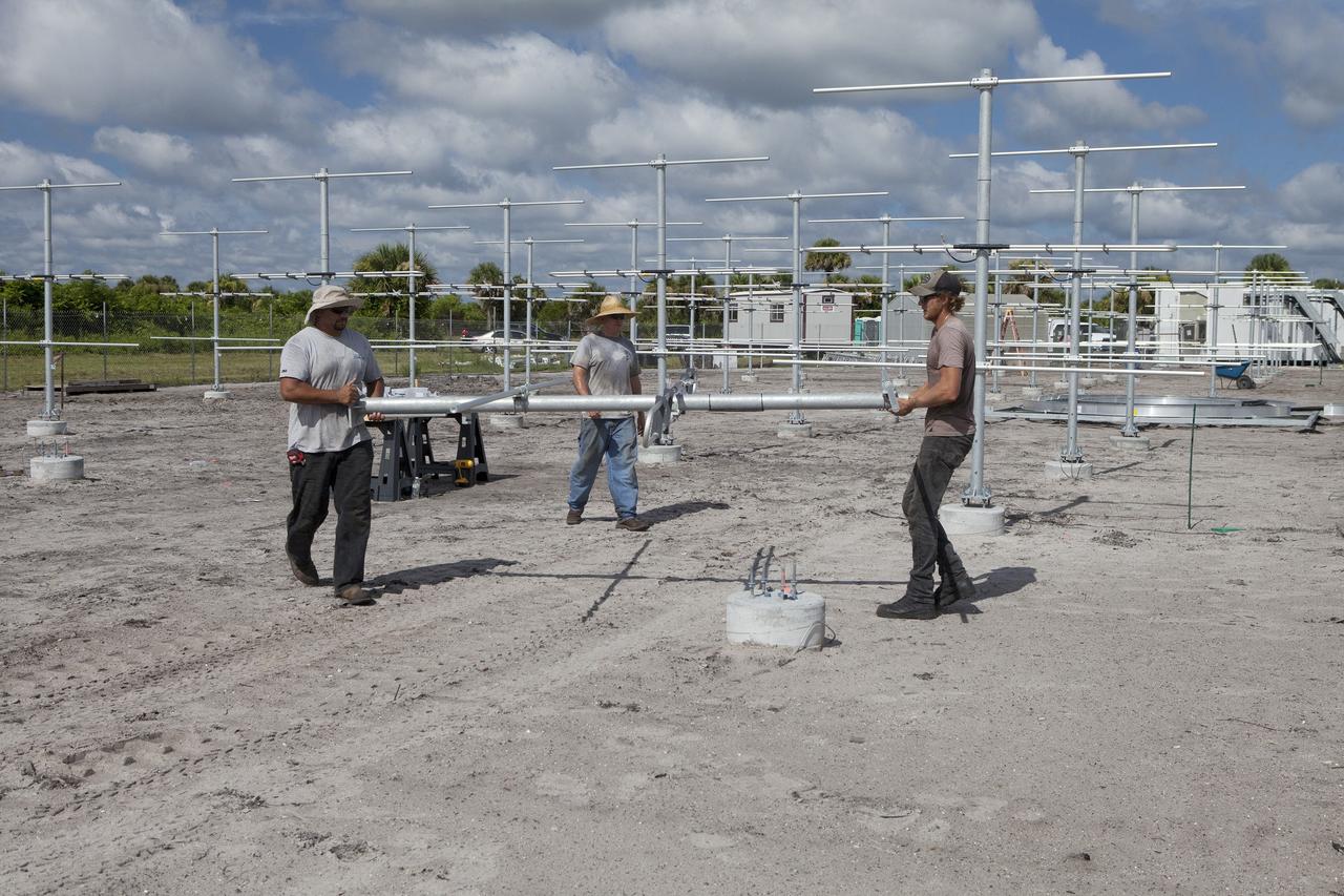 CAPE CANAVERAL, Fla. – From left, Felix Gamez, Robert Novak and Jacob Walls of Qinetiq North America prepare to install an antenna in the antenna field for NASA Kennedy Space Center’s Doppler radar wind profiler.     Located near the spaceport’s Shuttle Landing Facility runway, the profiler is being upgraded to a new, state-of-the-art version that will help forecasters and launch teams characterize upper-level winds in the area. This profiler will help in the detection of wind-shear conditions during launch. Photo credit: NASA/Ben Smegelsky