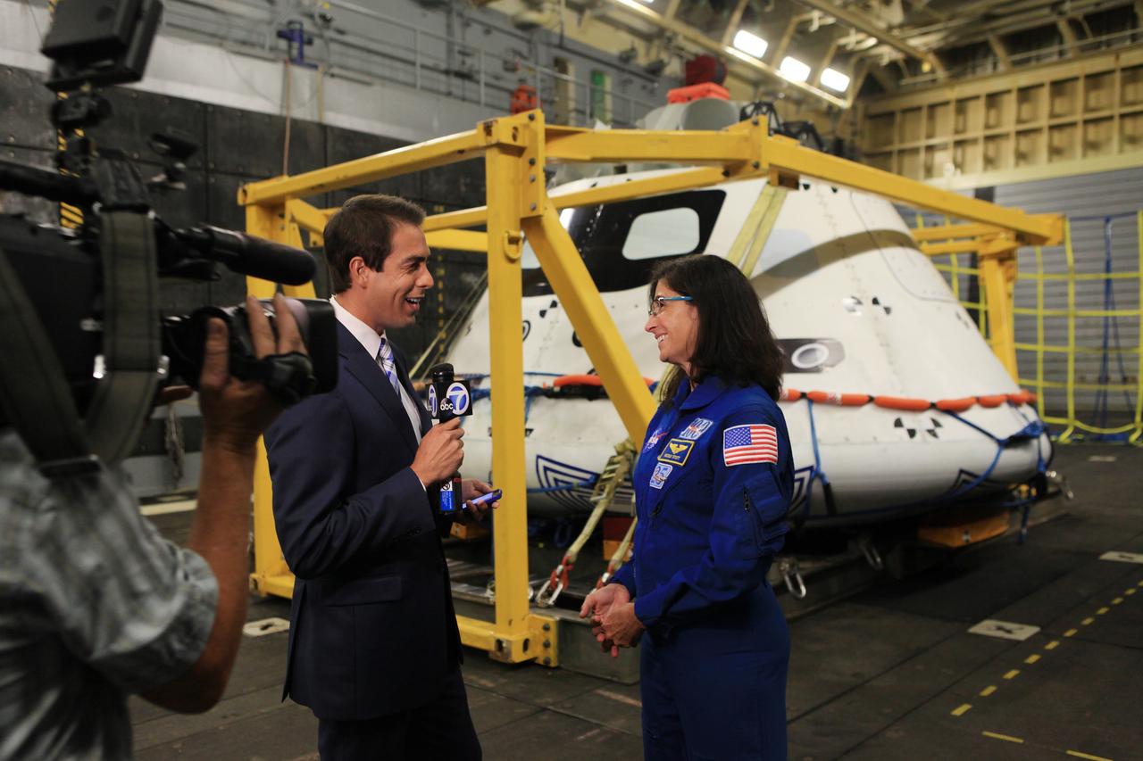LOS ANGELES, Calif. – NASA astronaut Nicole Stott talks with a reporter in the well deck of the USS Anchorage during L.A. Navy Days in Los Angeles. NASA, Lockheed Martin and the U.S. Navy completed Underway Recovery Test 2 on the Orion boilerplate test vehicle in the Pacific Ocean off the coast of San Diego to prepare for recovery of the Orion crew module on its return from a deep space mission. The underway recovery test allowed the teams to demonstrate and evaluate the recovery processes, procedures, new hardware and personnel in open waters.    The Ground Systems Development and Operations Program conducted the underway recovery test. Orion is the exploration spacecraft designed to carry astronauts to destinations not yet explored by humans, including an asteroid and Mars. It will have emergency abort capability, sustain the crew during space travel and provide safe re-entry from deep space return velocities. The first unpiloted test flight of the Orion is scheduled to launch in 2014 atop a Delta IV rocket and in 2017 on NASA’s Space Launch System rocket. For more information, visit http://www.nasa.gov/orion. Photo credit: Kim Shiflett