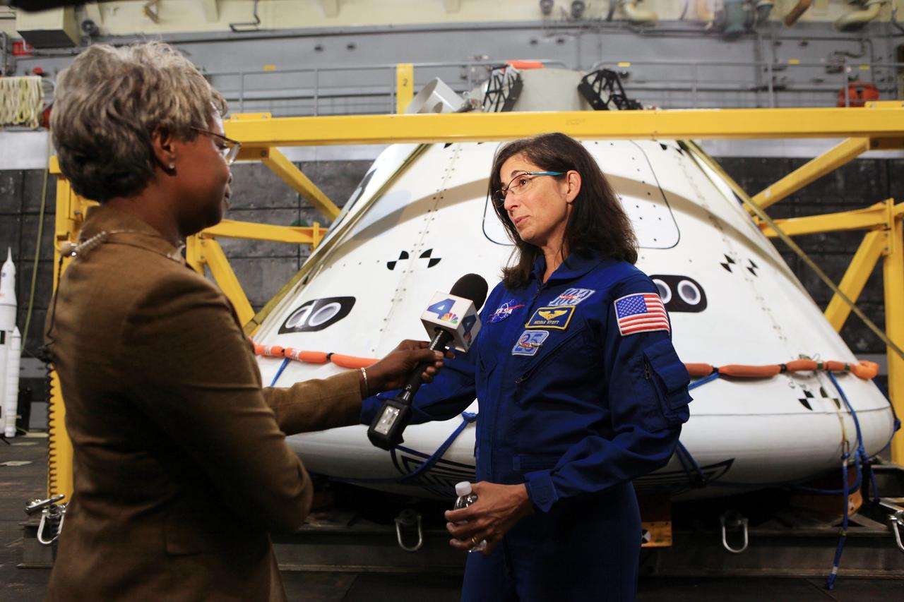 LOS ANGELES, Calif. – NASA astronaut Nicole Stott talks with a reporter in the well deck of the USS Anchorage during L.A. Navy Days in Los Angeles. NASA, Lockheed Martin and the U.S. Navy completed Underway Recovery Test 2 on the Orion boilerplate test vehicle in the Pacific Ocean off the coast of San Diego to prepare for recovery of the Orion crew module on its return from a deep space mission. The underway recovery test allowed the teams to demonstrate and evaluate the recovery processes, procedures, new hardware and personnel in open waters.    The Ground Systems Development and Operations Program conducted the underway recovery test. Orion is the exploration spacecraft designed to carry astronauts to destinations not yet explored by humans, including an asteroid and Mars. It will have emergency abort capability, sustain the crew during space travel and provide safe re-entry from deep space return velocities. The first unpiloted test flight of the Orion is scheduled to launch in 2014 atop a Delta IV rocket and in 2017 on NASA’s Space Launch System rocket. For more information, visit http://www.nasa.gov/orion. Photo credit: Kim Shiflett