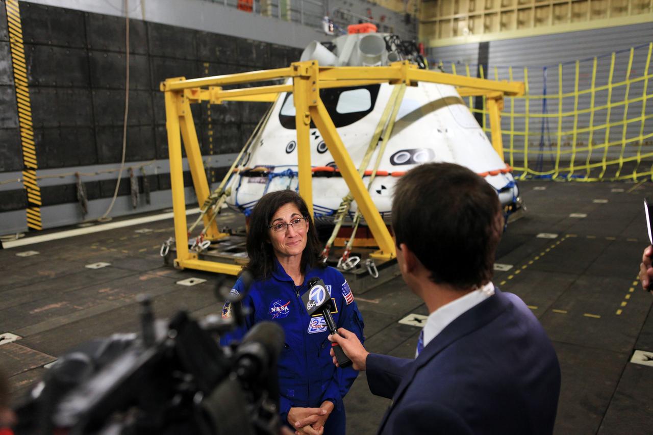 LOS ANGELES, Calif. – NASA astronaut Nicole Stott talks with a reporter in the well deck of the USS Anchorage during L.A. Navy Days in Los Angeles. NASA, Lockheed Martin and the U.S. Navy completed Underway Recovery Test 2 on the Orion boilerplate test vehicle in the Pacific Ocean off the coast of San Diego to prepare for recovery of the Orion crew module on its return from a deep space mission. The underway recovery test allowed the teams to demonstrate and evaluate the recovery processes, procedures, new hardware and personnel in open waters    The Ground Systems Development and Operations Program conducted the underway recovery test. Orion is the exploration spacecraft designed to carry astronauts to destinations not yet explored by humans, including an asteroid and Mars. It will have emergency abort capability, sustain the crew during space travel and provide safe re-entry from deep space return velocities. The first unpiloted test flight of the Orion is scheduled to launch in 2014 atop a Delta IV rocket and in 2017 on NASA’s Space Launch System rocket. For more information, visit http://www.nasa.gov/orion. Photo credit: Kim Shiflett