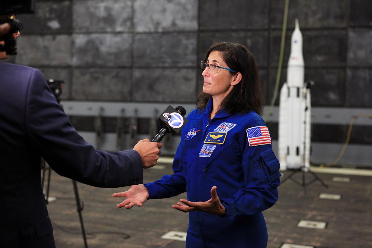 LOS ANGELES, Calif. – NASA astronaut Nicole Stott talks with a reporter in the well deck of the USS Anchorage during L.A. Navy Days in Los Angeles. NASA, Lockheed Martin and the U.S. Navy completed Underway Recovery Test 2 on the Orion boilerplate test vehicle in the Pacific Ocean off the coast of San Diego to prepare for recovery of the Orion crew module on its return from a deep space mission. The underway recovery test allowed the teams to demonstrate and evaluate the recovery processes, procedures, new hardware and personnel in open waters. Behind Stott is a model of NASA’s Space Launch System and Orion spacecraft.    The Ground Systems Development and Operations Program conducted the underway recovery test. Orion is the exploration spacecraft designed to carry astronauts to destinations not yet explored by humans, including an asteroid and Mars. It will have emergency abort capability, sustain the crew during space travel and provide safe re-entry from deep space return velocities. The first unpiloted test flight of the Orion is scheduled to launch in 2014 atop a Delta IV rocket and in 2017 on NASA’s Space Launch System rocket. For more information, visit http://www.nasa.gov/orion. Photo credit: Kim Shiflett