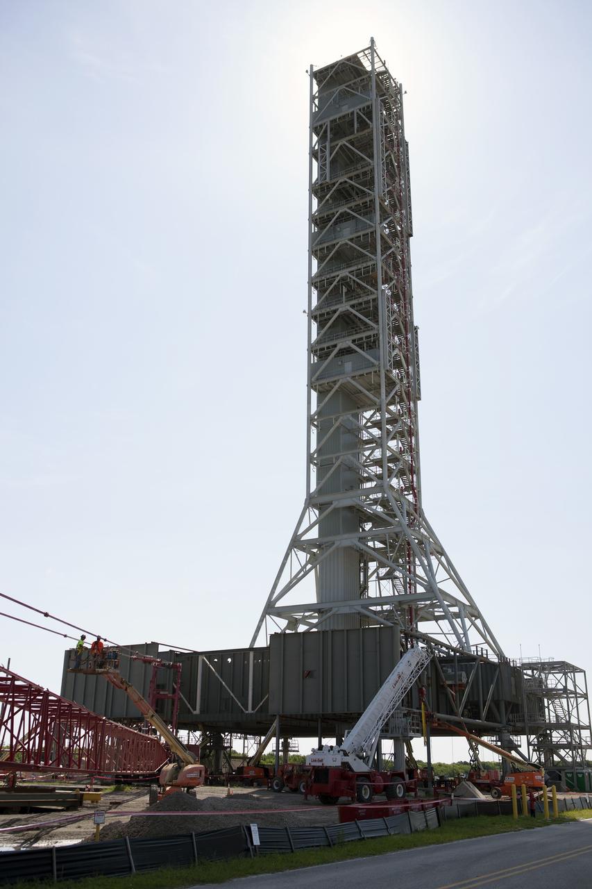 CAPE CANAVERAL, Fla. – Modifications continue on the Mobile Launcher, or ML, at the Mobile Launcher Park Site at NASA’s Kennedy Space Center in Florida. The ML is being modified and strengthened to accommodate the weight, size and thrust at launch of NASA's Space Launch System, or SLS, and Orion spacecraft.    In 2013, the agency awarded a contract to J.P. Donovan Construction Inc. of Rockledge, Fla., to modify the ML, which is one of the key elements of ground support equipment that is being upgraded by the Ground Systems Development and Operations Program at Kennedy. The existing 24-foot exhaust hole is being enlarged and strengthened for the larger, heavier SLS rocket. The ML will carry the SLS rocket and Orion spacecraft to Launch Pad 39B for its first mission, Exploration Mission-1, in 2017. Photo credit: NASA/Dimitri Gerondidakis