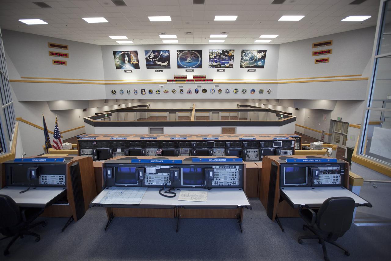 CAPE CANAVERAL, Fla. – Inside Firing Room 4 in the Launch Control Center at NASA's Kennedy Space Center in Florida, the outer walls, inner walls, windows and doors for the four separate firing rooms on the main floor have been completed. Three rows of upper level management consoles remain and could be used as a fifth firing room. The Ground Systems Development and Operations Program is overseeing the efforts to create a new firing room based on a multi-user concept. The space shuttle mission plaques and posters remain on the wall above the firing rooms.    The design of Firing Room 4 incorporates five control room areas that can be flexible to meet current and future NASA and commercial user requirements. The equipment and most of the consoles from Firing Room 4 were moved to Firing Room 2 for possible future reuse. Photo credit: NASA/Dimitri Gerondidakis