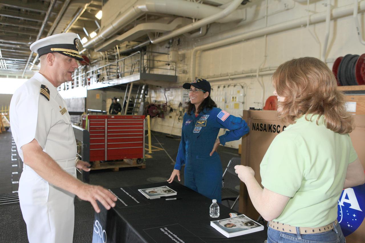 LOS ANGELES, Calif. – NASA astronaut Nicole Stott prepares for the Science, Technology, Engineering and Mathematics, or STEM, Expo for L.A. Navy Days in the well deck of the USS Anchorage at the Port of Los Angeles in California. At left, is Commanding Officer Joel G. Stewart, USS Anchorage. Visitors will have the opportunity to meet Stott and view the Orion boilerplate test vehicle secured in its recovery cradle. NASA, Lockheed Martin and the U.S. Navy completed Underway Recovery Test 2 in the Pacific Ocean off the coast of San Diego to prepare for recovery of the Orion crew module on its return from a deep space mission. The underway recovery test allowed the teams to demonstrate and evaluate the recovery processes, procedures, new hardware and personnel in open waters. The Ground Systems Development and Operations Program conducted the underway recovery test. Orion is the exploration spacecraft designed to carry astronauts to destinations not yet explored by humans, including an asteroid and Mars. It will have emergency abort capability, sustain the crew during space travel and provide safe re-entry from deep space return velocities. The first unpiloted test flight of the Orion is scheduled to launch in 2014 on Exploration Flight Test-1, or EFT-1, atop a Delta IV rocket and in 2017 on NASA’s Space Launch System rocket. For more information, visit http://www.nasa.gov/orion. Photo credit: Kim Shiflett