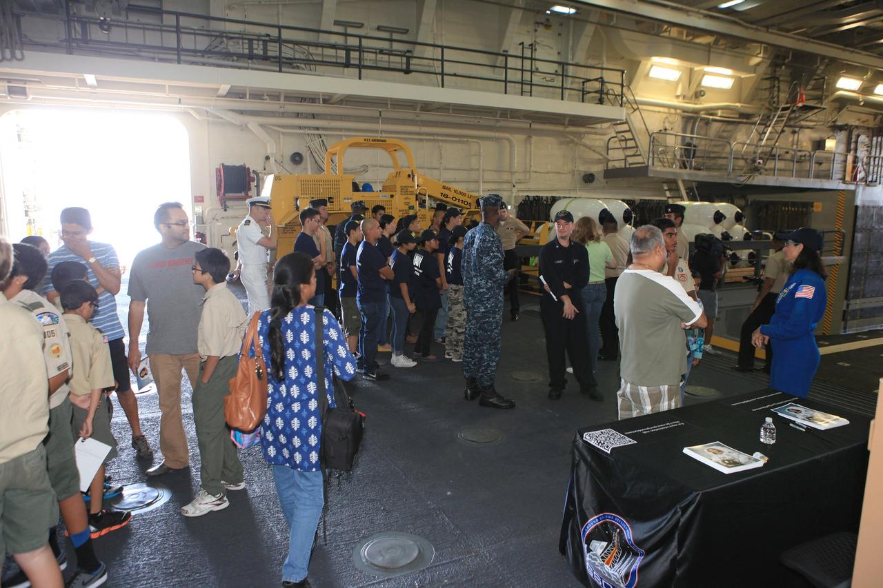 LOS ANGELES, Calif. – Visitors tour the well deck of the USS Anchorage during the Science, Technology, Engineering and Mathematics, or STEM, Expo for L.A. Navy Days at the Port of Los Angeles in California. At far right is NASA astronaut Nicole Stott. NASA, Lockheed Martin and the U.S. Navy completed Underway Recovery Test 2 on the Orion boilerplate test vehicle in the Pacific Ocean off the coast of San Diego to prepare for recovery of the Orion crew module on its return from a deep space mission. The underway recovery test allowed the teams to demonstrate and evaluate the recovery processes, procedures, new hardware and personnel in open waters.    The Ground Systems Development and Operations Program conducted the underway recovery test. Orion is the exploration spacecraft designed to carry astronauts to destinations not yet explored by humans, including an asteroid and Mars. It will have emergency abort capability, sustain the crew during space travel and provide safe re-entry from deep space return velocities. The first unpiloted test flight of the Orion is scheduled to launch in 2014 on Exploration Flight Test-1, or EFT-1, atop a Delta IV rocket and in 2017 on NASA’s Space Launch System rocket. For more information, visit http://www.nasa.gov/orion. Photo credit: Kim Shiflett