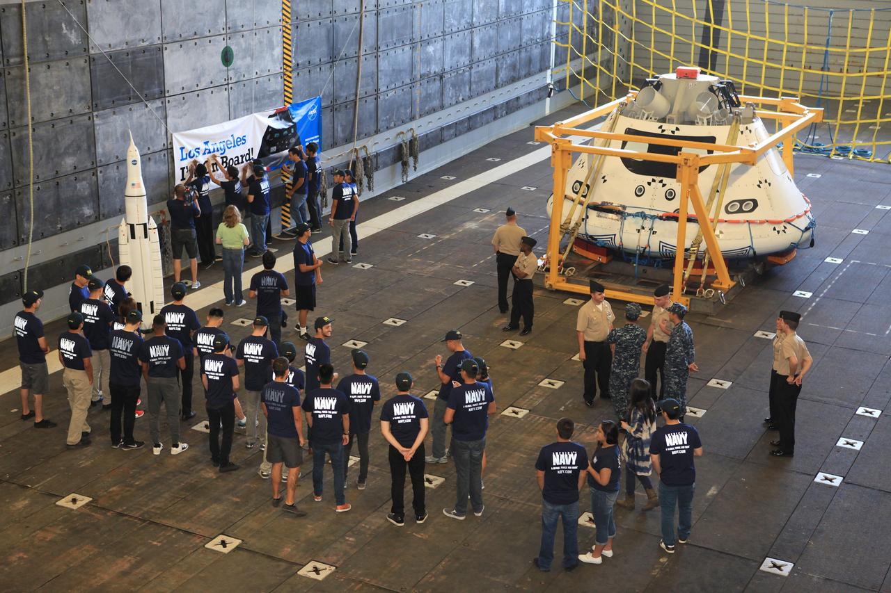 LOS ANGELES, Calif. – Visitors tour the well deck of the USS Anchorage and view the Orion boilerplate test vehicle secured in its recovery cradle during the Science, Technology, Engineering and Mathematics, or STEM, Expo for L.A. Navy Days at the Port of Los Angeles in California. At left is a mockup of NASA’s Space Launch System and Orion spacecraft. NASA, Lockheed Martin and the U.S. Navy completed Underway Recovery Test 2 on the Orion test vehicle in the Pacific Ocean off the coast of San Diego to prepare for recovery of the Orion crew module on its return from a deep space mission. The underway recovery test allowed the teams to demonstrate and evaluate the recovery processes, procedures, new hardware and personnel in open waters.    The Ground Systems Development and Operations Program conducted the underway recovery test. Orion is the exploration spacecraft designed to carry astronauts to destinations not yet explored by humans, including an asteroid and Mars. It will have emergency abort capability, sustain the crew during space travel and provide safe re-entry from deep space return velocities. The first unpiloted test flight of the Orion is scheduled to launch in 2014 on Exploration Flight Test-1, or EFT-1, atop a Delta IV rocket and in 2017 on NASA’s Space Launch System rocket. For more information, visit http://www.nasa.gov/orion. Photo credit: Kim Shiflett