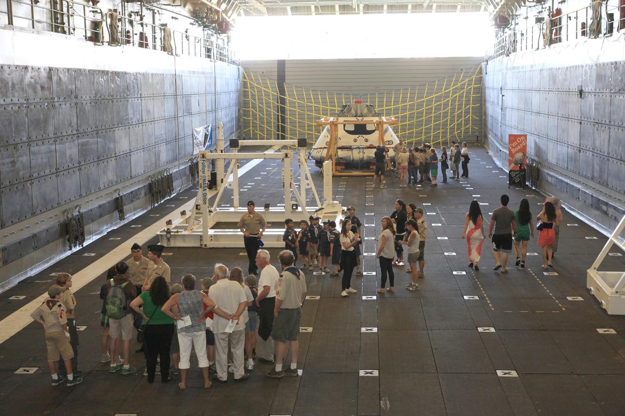 LOS ANGELES, Calif. – Visitors tour the well deck of the USS Anchorage and view the Orion boilerplate test vehicle secured in its recovery cradle during the Science, Technology, Engineering and Mathematics, or STEM, Expo for L.A. Navy Days at the Port of Los Angeles in California. Near the front of the well deck, at left, is a mockup of NASA’s Space Launch System and Orion spacecraft. NASA, Lockheed Martin and the U.S. Navy completed Underway Recovery Test 2 on the Orion test vehicle in the Pacific Ocean off the coast of San Diego to prepare for recovery of the Orion crew module on its return from a deep space mission. The underway recovery test allowed the teams to demonstrate and evaluate the recovery processes, procedures, new hardware and personnel in open waters.    The Ground Systems Development and Operations Program conducted the underway recovery test. Orion is the exploration spacecraft designed to carry astronauts to destinations not yet explored by humans, including an asteroid and Mars. It will have emergency abort capability, sustain the crew during space travel and provide safe re-entry from deep space return velocities. The first unpiloted test flight of the Orion is scheduled to launch in 2014 on Exploration Flight Test-1, or EFT-1, atop a Delta IV rocket and in 2017 on NASA’s Space Launch System rocket. For more information, visit http://www.nasa.gov/orion. Photo credit: Kim Shiflett