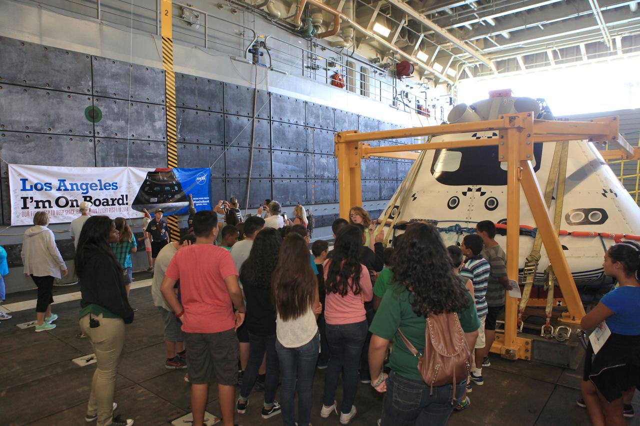 LOS ANGELES, Calif. – Visitors tour the well deck of the USS Anchorage and view the Orion boilerplate test vehicle secured in its recovery cradle during the Science, Technology, Engineering and Mathematics, or STEM, Expo for L.A. Navy Days at the Port of Los Angeles, California. NASA, Lockheed Martin and the U.S. Navy completed Underway Recovery Test 2 on the Orion test vehicle in the Pacific Ocean off the coast of San Diego to prepare for recovery of the Orion crew module on its return from a deep space mission. The underway recovery test allowed the teams to demonstrate and evaluate the recovery processes, procedures, new hardware and personnel in open waters.    The Ground Systems Development and Operations Program conducted the underway recovery test. Orion is the exploration spacecraft designed to carry astronauts to destinations not yet explored by humans, including an asteroid and Mars. It will have emergency abort capability, sustain the crew during space travel and provide safe re-entry from deep space return velocities. The first unpiloted test flight of the Orion is scheduled to launch in 2014 on Exploration Flight Test-1, or EFT-1, atop a Delta IV rocket and in 2017 on NASA’s Space Launch System rocket. For more information, visit http://www.nasa.gov/orion. Photo credit: Kim Shiflett