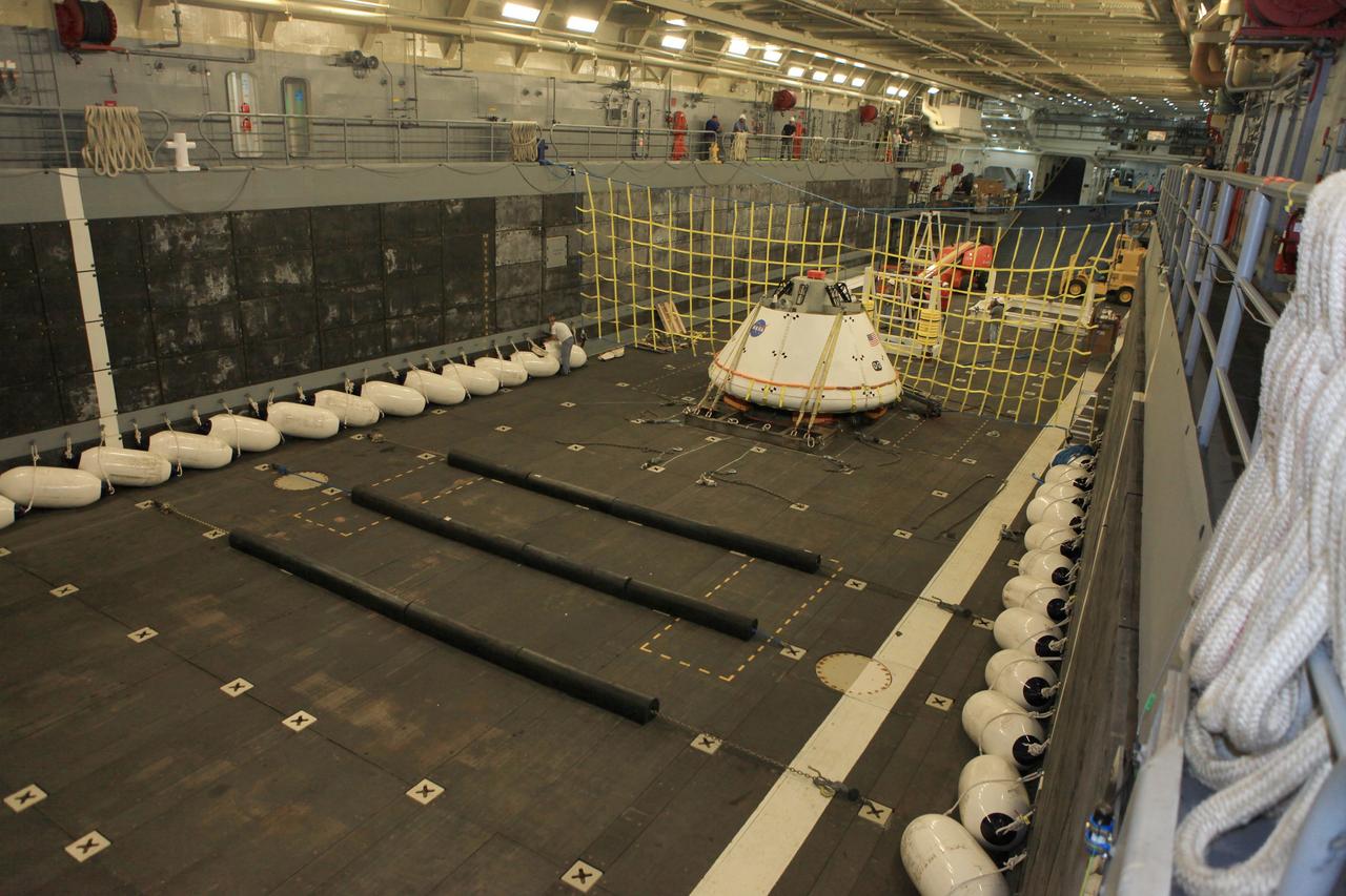 SAN DIEGO, Calif. – The Orion boilerplate test vehicle is secured on its cradle in the well deck of the U.S. Navy's USS Anchorage in preparation for Underway Recovery Test 2 in the Pacific Ocean off the coast of San Diego. A safety barrier has been installed near the test vehicle to keep it from going further into the well deck as it fills with water. NASA, Lockheed Martin and the U.S. Navy will conduct the test to prepare for recovery of the Orion crew module on its return from a deep space mission. The underway recovery test will allow the team to demonstrate and evaluate the recovery processes, procedures, new hardware and personnel in open waters.    The Ground Systems Development and Operations Program is conducting the underway recovery test. Orion is the exploration spacecraft designed to carry astronauts to destinations not yet explored by humans, including an asteroid and Mars. It will have emergency abort capability, sustain the crew during space travel and provide safe re-entry from deep space return velocities. The first unpiloted test flight of the Orion is scheduled to launch in 2014 atop a Delta IV rocket and in 2017 on NASA’s Space Launch System rocket. For more information, visit http://www.nasa.gov/orion. Photo credit: NASA/Kim Shiflett