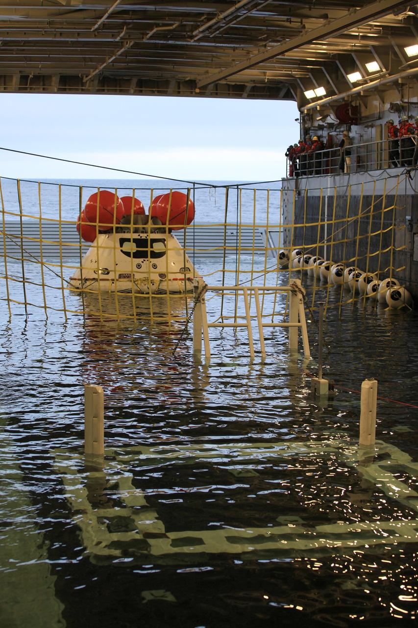 SAN DIEGO, Calif. – Inside the U.S. Navy’s USS Anchorage, the well deck has filled with water around the Orion boilerplate test vehicle in preparation for a portion of Underway Recovery Test 2 in the Pacific Ocean off the coast of San Diego. Tether lines are attached to the test vehicle to control it and a safety barrier has been installed to prevent Orion from going further in the well deck. NASA, Lockheed Martin and the U.S. Navy will conduct the test to prepare for recovery of the Orion crew module on its return from a deep space mission. The underway recovery test will allow the team to demonstrate and evaluate the recovery processes, procedures, new hardware and personnel in open waters.    The Ground Systems Development and Operations Program is conducting the underway recovery test. Orion is the exploration spacecraft designed to carry astronauts to destinations not yet explored by humans, including an asteroid and Mars. It will have emergency abort capability, sustain the crew during space travel and provide safe re-entry from deep space return velocities. The first unpiloted test flight of the Orion is scheduled to launch in 2014 atop a Delta IV rocket and in 2017 on NASA’s Space Launch System rocket. For more information, visit http://www.nasa.gov/orion. Photo credit: NASA/Kim Shiflett