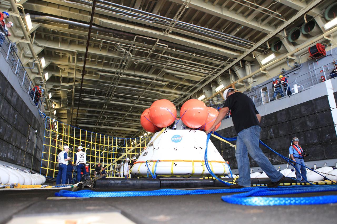 SAN DIEGO, Calif. – Inside the well deck of the U.S. Navy's USS Anchorage, the Orion boilerplate test vehicle has been moved from its cradle onto a set of rubber shock absorbers as part of Underway Recovery Test 2. Testing of the tether lines attached to Orion is underway. NASA, Lockheed Martin and the U.S. Navy are conducting the test in the Pacific Ocean off the coast of San Diego to prepare for recovery of the Orion crew module on its return from a deep space mission. The underway recovery test will allow the team to demonstrate and evaluate the recovery processes, procedures, new hardware and personnel in open waters.    The Ground Systems Development and Operations Program is conducting the underway recovery test. Orion is the exploration spacecraft designed to carry astronauts to destinations not yet explored by humans, including an asteroid and Mars. It will have emergency abort capability, sustain the crew during space travel and provide safe re-entry from deep space return velocities. The first unpiloted test flight of the Orion is scheduled to launch in 2014 atop a Delta IV rocket and in 2017 on NASA’s Space Launch System rocket. For more information, visit http://www.nasa.gov/orion. Photo credit: NASA/Kim Shiflett