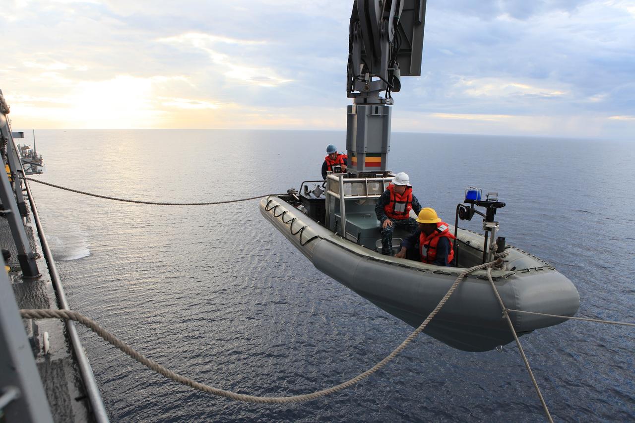 SAN DIEGO, Calif. – U.S. Navy personnel in a rigid hull inflatable boat watch as a crane moves them away from the USS Anchorage during a portion of the Orion Underway Recovery Test 2 in the Pacific Ocean off the coast of San Diego. NASA, Lockheed Martin and the U.S. Navy are conducting the test on the Orion boilerplate test vehicle to prepare for recovery of the Orion crew module on its return from a deep space mission. The underway recovery test will allow the team to demonstrate and evaluate the recovery processes, procedures, new hardware and personnel in open waters.    The Ground Systems Development and Operations Program is conducting the underway recovery test. Orion is the exploration spacecraft designed to carry astronauts to destinations not yet explored by humans, including an asteroid and Mars. It will have emergency abort capability, sustain the crew during space travel and provide safe re-entry from deep space return velocities. The first unpiloted test flight of the Orion is scheduled to launch in 2014 atop a Delta IV rocket and in 2017 on NASA’s Space Launch System rocket. For more information, visit http://www.nasa.gov/orion. Photo credit: NASA/Kim Shiflett