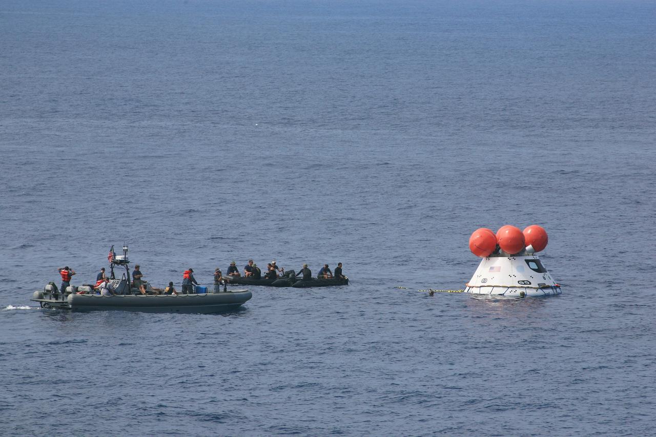 SAN DIEGO, Calif. – U.S. Navy personnel in a rigid hull inflatable boat and U.S. Navy divers in a Zodiac boat attach tether lines to NASA’s Orion boilerplate test vehicle as it floats in the Pacific Ocean off the coast of San Diego during a portion of the Underway Recovery Test 2. The U.S. Navy’s USS Anchorage is ready for recovery nearby.    The testing is being conducted to prepare for recovery of the Orion crew module on its return from a deep-space mission. The underway recovery test will allow the team to demonstrate and evaluate the recovery processes, procedures, new hardware and personnel in open waters. The Ground Systems Development and Operations Program is conducting the underway recovery test. Orion is the exploration spacecraft designed to carry astronauts to destinations not yet explored by humans, including an asteroid and Mars. It will have emergency abort capability, sustain the crew during space travel and provide safe re-entry from deep-space return velocities. The first unpiloted test flight of the Orion is scheduled to launch in 2014 atop a Delta IV rocket and in 2017 on NASA’s Space Launch System rocket. For more information, visit http://www.nasa.gov/orion. Photo credit: NASA/Kim Shiflett