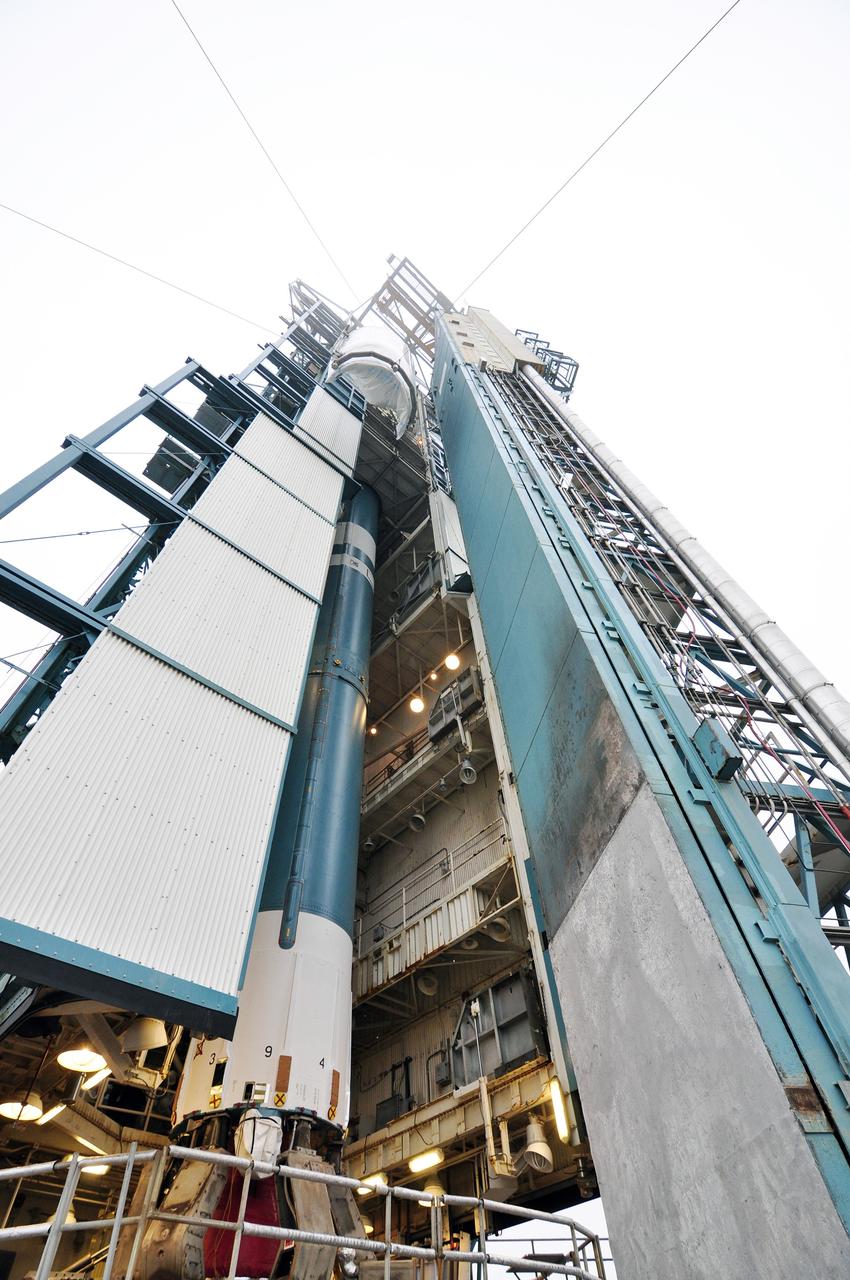 VANDENBERG AIR FORCE BASE, Calif. – A half section of the 10-foot-diameter fairing for NASA's Soil Moisture Active Passive mission, or SMAP, is hoisted toward the environmental enclosure at the top of the mobile service tower at Space Launch Complex 2 on Vandenberg Air Force Base in California, past the Delta II first stage.    The fairing will protect the SMAP spacecraft from the heat and aerodynamic pressure generated during its ascent to orbit aboard a United Launch Alliance Delta II rocket. SMAP will provide global measurements of soil moisture and its freeze/thaw state. These measurements will be used to enhance understanding of processes that link the water, energy and carbon cycles, and to extend the capabilities of weather and climate prediction models. SMAP data will also be used to quantify net carbon flux in boreal landscapes and to develop improved flood prediction and drought monitoring capabilities. Launch is scheduled for no earlier than November 2014. To learn more about SMAP, visit http://smap.jpl.nasa.gov.  Photo credit: NASA/Randy Beaudoin
