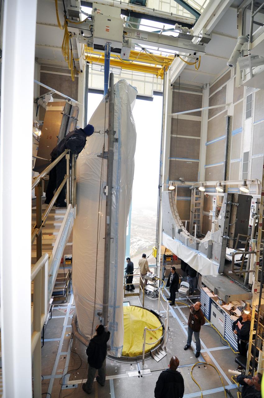VANDENBERG AIR FORCE BASE, Calif. – A half section of the 10-foot-diameter fairing for NASA's Soil Moisture Active Passive mission, or SMAP, is placed into position in the environmental enclosure at the top of the mobile service tower at Space Launch Complex 2 on Vandenberg Air Force Base in California.    The fairing will protect the SMAP spacecraft from the heat and aerodynamic pressure generated during its ascent to orbit aboard a United Launch Alliance Delta II rocket. SMAP will provide global measurements of soil moisture and its freeze/thaw state. These measurements will be used to enhance understanding of processes that link the water, energy and carbon cycles, and to extend the capabilities of weather and climate prediction models. SMAP data will also be used to quantify net carbon flux in boreal landscapes and to develop improved flood prediction and drought monitoring capabilities. Launch is scheduled for no earlier than November 2014. To learn more about SMAP, visit http://smap.jpl.nasa.gov.  Photo credit: NASA/Randy Beaudoin