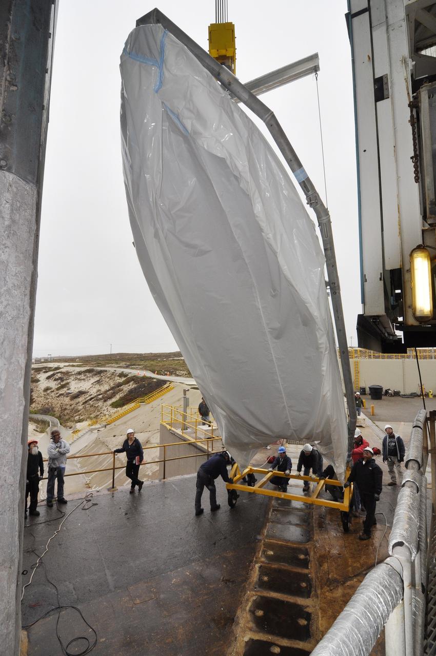VANDENBERG AIR FORCE BASE, Calif. – A half section of the 10-foot-diameter fairing for NASA's Soil Moisture Active Passive mission, or SMAP, is lifted into a vertical position during preparations to hoist it into the environmental enclosure at the top of the mobile service tower at Space Launch Complex 2 on Vandenberg Air Force Base in California.    The fairing will protect the SMAP spacecraft from the heat and aerodynamic pressure generated during its ascent to orbit aboard a United Launch Alliance Delta II rocket. SMAP will provide global measurements of soil moisture and its freeze/thaw state. These measurements will be used to enhance understanding of processes that link the water, energy and carbon cycles, and to extend the capabilities of weather and climate prediction models. SMAP data will also be used to quantify net carbon flux in boreal landscapes and to develop improved flood prediction and drought monitoring capabilities. Launch is scheduled for no earlier than November 2014. To learn more about SMAP, visit http://smap.jpl.nasa.gov.  Photo credit: NASA/Randy Beaudoin