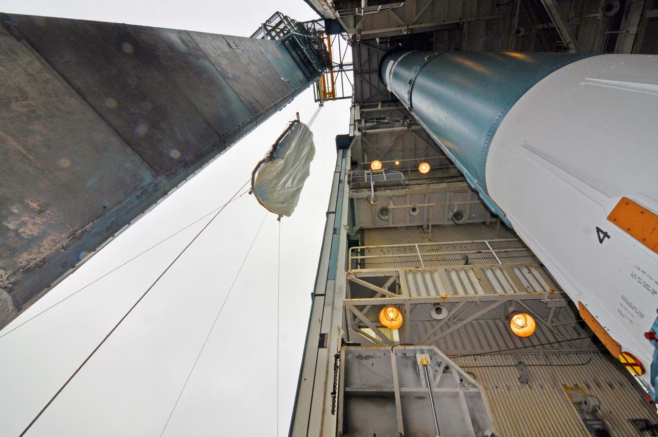 VANDENBERG AIR FORCE BASE, Calif. – A half section of the 10-foot-diameter fairing for NASA's Soil Moisture Active Passive mission, or SMAP, is hoisted past the Delta II first stage on its way to the environmental enclosure at the top of the mobile service tower at Space Launch Complex 2 on Vandenberg Air Force Base in California.    The fairing will protect the SMAP spacecraft from the heat and aerodynamic pressure generated during its ascent to orbit aboard a United Launch Alliance Delta II rocket. SMAP will provide global measurements of soil moisture and its freeze/thaw state. These measurements will be used to enhance understanding of processes that link the water, energy and carbon cycles, and to extend the capabilities of weather and climate prediction models. SMAP data will also be used to quantify net carbon flux in boreal landscapes and to develop improved flood prediction and drought monitoring capabilities. Launch is scheduled for no earlier than November 2014. To learn more about SMAP, visit http://smap.jpl.nasa.gov.  Photo credit: NASA/Randy Beaudoin