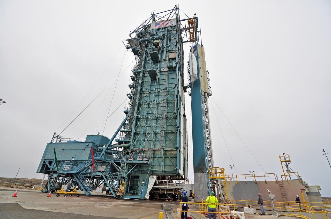 VANDENBERG AIR FORCE BASE, Calif. – A half section of the 10-foot-diameter fairing for NASA's Soil Moisture Active Passive mission, or SMAP, is hoisted to the top of the mobile service tower at Space Launch Complex 2 on Vandenberg Air Force Base in California where it will be transferred into the environmental enclosure and stowed until arrival of the spacecraft.     The fairing will protect the SMAP spacecraft from the heat and aerodynamic pressure generated during its ascent to orbit aboard a United Launch Alliance Delta II rocket. SMAP will provide global measurements of soil moisture and its freeze/thaw state. These measurements will be used to enhance understanding of processes that link the water, energy and carbon cycles, and to extend the capabilities of weather and climate prediction models. SMAP data will also be used to quantify net carbon flux in boreal landscapes and to develop improved flood prediction and drought monitoring capabilities. Launch is scheduled for no earlier than November 2014. To learn more about SMAP, visit http://smap.jpl.nasa.gov.  Photo credit: NASA/Randy Beaudoin