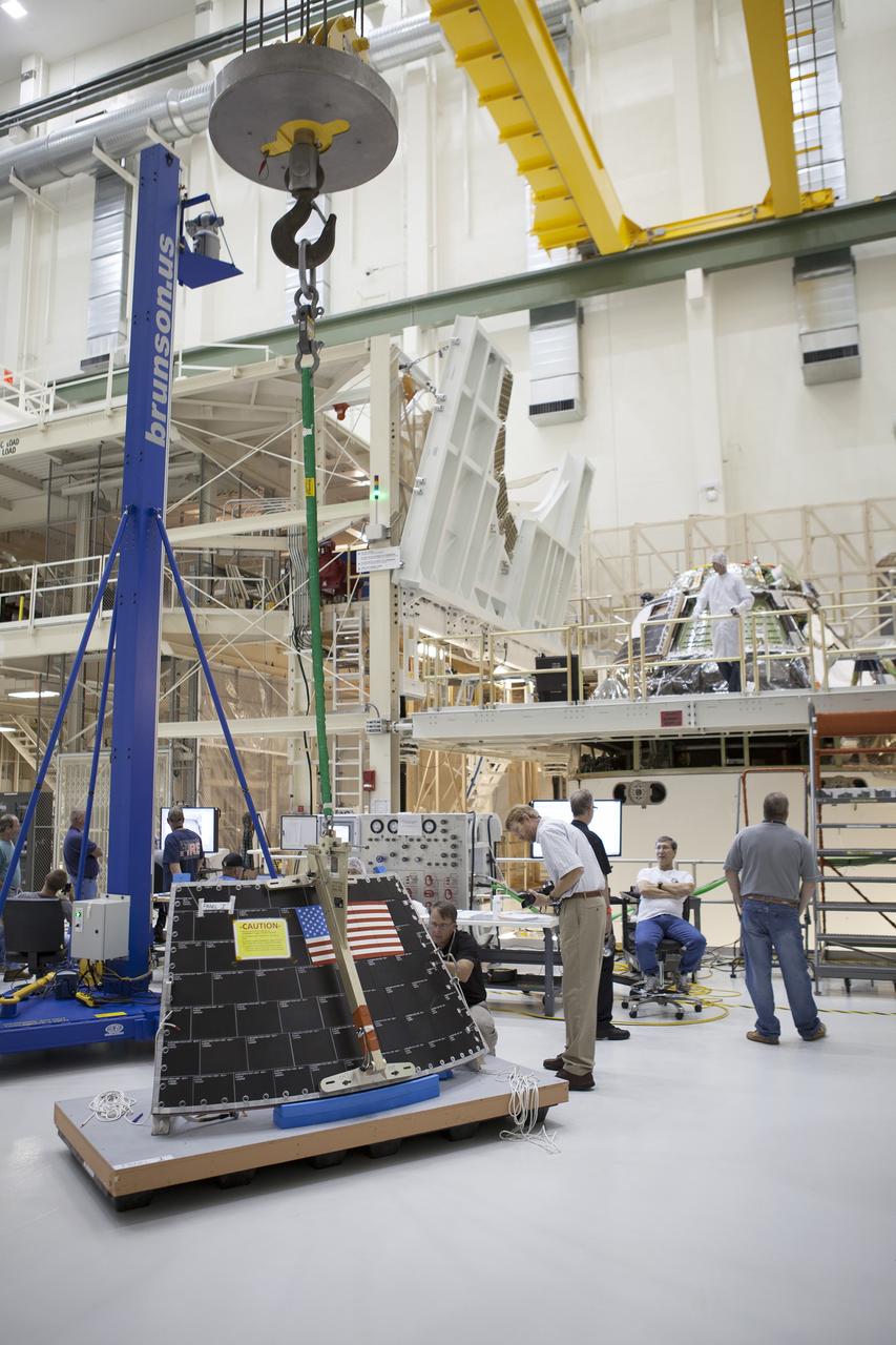 CAPE CANAVERAL, Fla. – Inside the Operations and Checkout Building high bay at NASA's Kennedy Space Center in Florida, a crane is attached to the middle back shell tile panel in order to lift it for installation on the Orion crew module. Preparations are underway for Exploration Flight Test-1, or EFT-1. Orion is the exploration spacecraft designed to carry astronauts to destinations not yet explored by humans, including an asteroid and Mars. It will have emergency abort capability, sustain the crew during space travel and provide safe re-entry from deep space return velocities. The first unpiloted test flight of the Orion is scheduled to launch later this year atop a Delta IV rocket from Cape Canaveral Air Force Station in Florida to an altitude of 3,600 miles above the Earth's surface. The two-orbit, four-hour flight test will help engineers evaluate the systems critical to crew safety including the heat shield, parachute system and launch abort system. For more information, visit http://www.nasa.gov/orion. Photo credit: NASA/Dimitri Gerondidakis