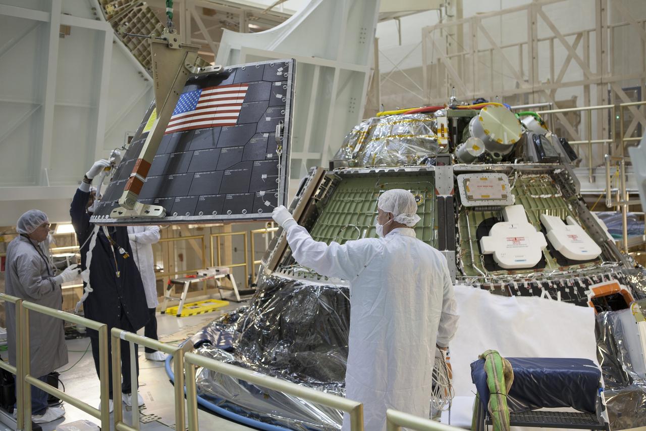 CAPE CANAVERAL, Fla. – Inside the Operations and Checkout Building high bay at NASA's Kennedy Space Center in Florida, technicians and engineers on a work platform monitor the progress as a crane is used to lower the middle back shell tile panel for installation on the Orion crew module. Preparations are underway for Exploration Flight Test-1, or EFT-1. Orion is the exploration spacecraft designed to carry astronauts to destinations not yet explored by humans, including an asteroid and Mars. It will have emergency abort capability, sustain the crew during space travel and provide safe re-entry from deep space return velocities. The first unpiloted test flight of the Orion is scheduled to launch later this year atop a Delta IV rocket from Cape Canaveral Air Force Station in Florida to an altitude of 3,600 miles above the Earth's surface. The two-orbit, four-hour flight test will help engineers evaluate the systems critical to crew safety including the heat shield, parachute system and launch abort system. For more information, visit http://www.nasa.gov/orion. Photo credit: NASA/Dimitri Gerondidakis