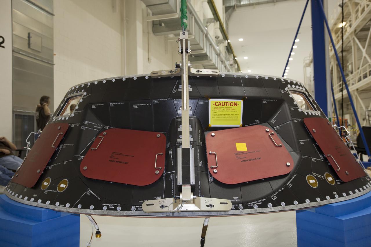 CAPE CANAVERAL, Fla. – Inside the Operations and Checkout Building high bay at NASA's Kennedy Space Center in Florida, a crane is attached to the middle back shell tile panel in order to lift it for installation on the Orion crew module. Preparations are underway for Exploration Flight Test-1, or EFT-1. Orion is the exploration spacecraft designed to carry astronauts to destinations not yet explored by humans, including an asteroid and Mars. It will have emergency abort capability, sustain the crew during space travel and provide safe re-entry from deep space return velocities. The first unpiloted test flight of the Orion is scheduled to launch later this year atop a Delta IV rocket from Cape Canaveral Air Force Station in Florida to an altitude of 3,600 miles above the Earth's surface. The two-orbit, four-hour flight test will help engineers evaluate the systems critical to crew safety including the heat shield, parachute system and launch abort system. For more information, visit http://www.nasa.gov/orion. Photo credit: NASA/Dimitri Gerondidakis