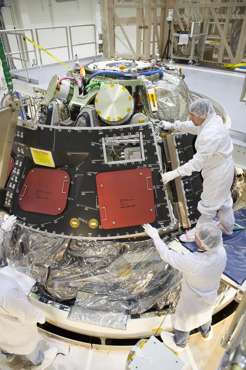 CAPE CANAVERAL, Fla. – Inside the Operations and Checkout Building high bay at NASA's Kennedy Space Center in Florida, technicians dressed in clean-room suits line up the middle back shell tile panel for installation on the Orion crew module. Preparations are underway for Exploration Flight Test-1, or EFT-1. Orion is the exploration spacecraft designed to carry astronauts to destinations not yet explored by humans, including an asteroid and Mars. It will have emergency abort capability, sustain the crew during space travel and provide safe re-entry from deep space return velocities. The first unpiloted test flight of the Orion is scheduled to launch later this year atop a Delta IV rocket from Cape Canaveral Air Force Station in Florida to an altitude of 3,600 miles above the Earth's surface. The two-orbit, four-hour flight test will help engineers evaluate the systems critical to crew safety including the heat shield, parachute system and launch abort system. For more information, visit http://www.nasa.gov/orion. Photo credit: NASA/Dimitri Gerondidakis