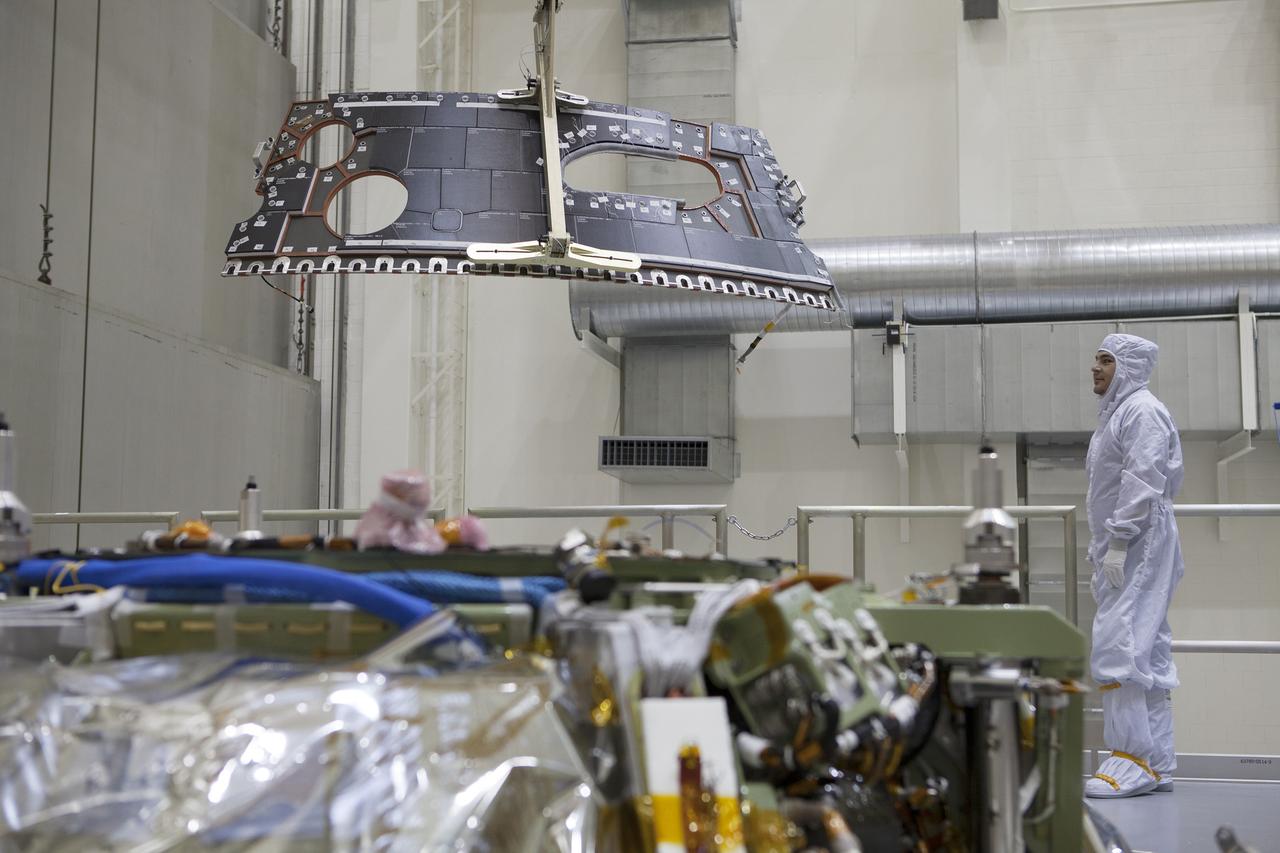 CAPE CANAVERAL, Fla. – Inside the Operations and Checkout Building high bay at NASA's Kennedy Space Center in Florida, a technician dressed in a clean-room suit monitors the progress as a crane is used to lower a back shell tile panel for installation on the Orion crew module. Preparations are underway for Exploration Flight Test-1, or EFT-1. Orion is the exploration spacecraft designed to carry astronauts to destinations not yet explored by humans, including an asteroid and Mars. It will have emergency abort capability, sustain the crew during space travel and provide safe re-entry from deep space return velocities. The first unpiloted test flight of the Orion is scheduled to launch later this year atop a Delta IV rocket from Cape Canaveral Air Force Station in Florida to an altitude of 3,600 miles above the Earth's surface. The two-orbit, four-hour flight test will help engineers evaluate the systems critical to crew safety including the heat shield, parachute system and launch abort system. For more information, visit http://www.nasa.gov/orion. Photo credit: NASA/Dimitri Gerondidakis