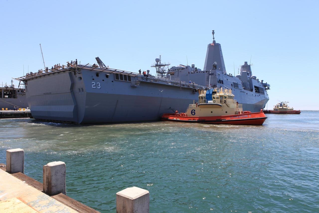 SAN DIEGO, Calif. – The USS Anchorage returns to Naval Base San Diego after completion of the Orion Underway Recovery Test 2 in the Pacific Ocean. Two tugboats help guide the ship into port. NASA, Lockheed Martin and the U.S. Navy conducted the test on the Orion boilerplate test vehicle to prepare for recovery of the Orion crew module on its return from a deep space mission. The underway recovery test allowed the team to demonstrate and evaluate the recovery processes, procedures, new hardware and personnel in open waters.    The Ground Systems Development and Operations Program conducted the underway recovery test. Orion is the exploration spacecraft designed to carry astronauts to destinations not yet explored by humans, including an asteroid and Mars. It will have emergency abort capability, sustain the crew during space travel and provide safe re-entry from deep space return velocities. The first unpiloted test flight of the Orion is scheduled to launch in 2014 atop a Delta IV rocket and in 2017 on NASA’s Space Launch System rocket. For more information, visit http://www.nasa.gov/orion. Photo credit: NASA/Kim Shiflett