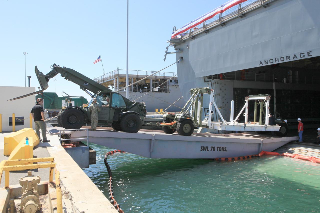 SAN DIEGO, Calif. – The USS Anchorage has docked at Naval Base San Diego after completion of the Orion Underway Recovery Test 2 in the Pacific Ocean. Support equipment used during the test is being offloaded from the ship's well deck. NASA, Lockheed Martin and the U.S. Navy conducted the test on the Orion boilerplate test vehicle to prepare for recovery of the Orion crew module on its return from a deep space mission. The underway recovery test allowed the team to demonstrate and evaluate the recovery processes, procedures, new hardware and personnel in open waters.    The Ground Systems Development and Operations Program conducted the underway recovery test. Orion is the exploration spacecraft designed to carry astronauts to destinations not yet explored by humans, including an asteroid and Mars. It will have emergency abort capability, sustain the crew during space travel and provide safe re-entry from deep space return velocities. The first unpiloted test flight of the Orion is scheduled to launch in 2014 atop a Delta IV rocket and in 2017 on NASA’s Space Launch System rocket. For more information, visit http://www.nasa.gov/orion. Photo credit: NASA/Kim Shiflett