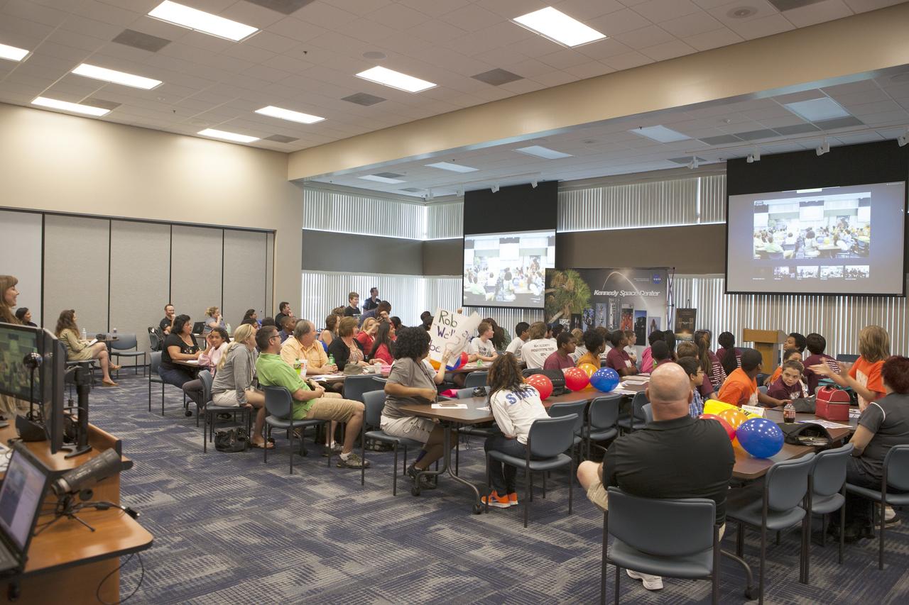 CAPE CANAVERAL, Fla. – Florida middle school students and their teachers greet students from other locations via webex before the start of the Zero Robotics finals competition. The Florida teams are at the Space Station Processing Facility at NASA's Kennedy Space Center in Florida. Students designed software to control Synchronized Position Hold Engage and Reorient Experimental Satellites, or SPHERES, and competed with other teams locally. The Zero Robotics is a robotics programming competition where the robots are SPHERES. The competition starts online, where teams program the SPHERES to solve an annual challenge. After several phases of virtual competition in a simulation environment that mimics the real SPHERES, finalists are selected to compete in a live championship aboard the space station. Students compete to win a technically challenging game by programming their strategies into the SPHERES satellites. The programs are autonomous and the students cannot control the satellites during the test. Photo credit: NASA/Daniel Casper