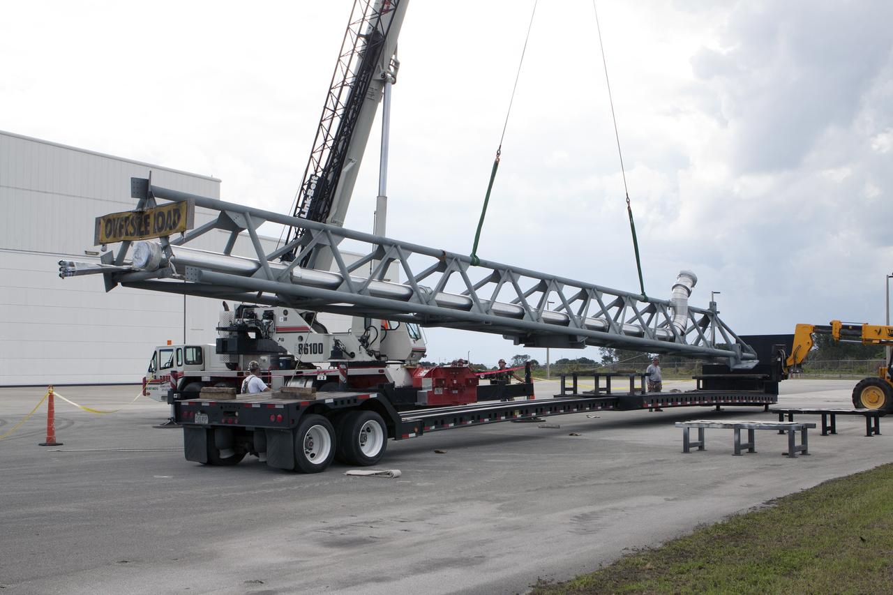 CAPE CANAVERAL, Fla. – The umbilical swing arm for Exploration Flight Test 1, or EFT-1, arrives at the Horizontal Integration Facility near Space Launch Complex 37 at Cape Canaveral Air Force Station in Florida and is being lifted by crane from its transporter. The swing arm is the uppermost of three swing arms that will be attached to the fixed umbilical tower on the launch pad.     The swing arm will carry umbilicals that will be mated to Orion's launch abort system and environmental control system. During launch, the umbilicals will pull away from Orion and the United Launch Alliance Delta IV Heavy rocket at T-0. During the EFT-1 mission, Orion will travel farther into space than any human spacecraft has gone in more than 40 years.  The data gathered during the flight will influence design decisions, validate existing computer models and innovative new approaches to space systems development, as well as reduce overall mission risks and costs for later Orion flights. Liftoff of Orion on its first flight test is planned for fall 2014. Photo credit: NASA/Kim Shiflett